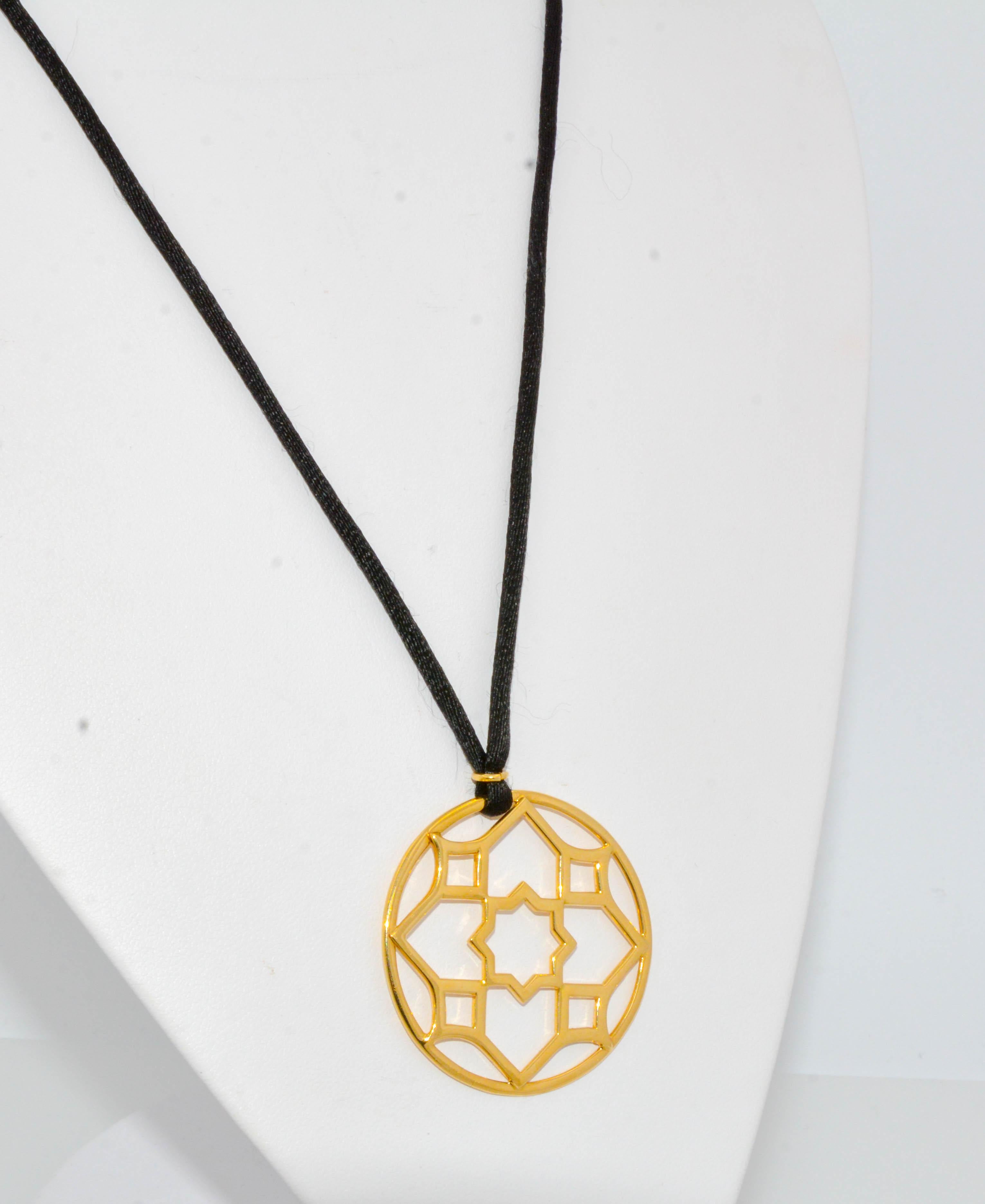 This 'Zellige' pendant is from the Paloma Picasso® Collection at Tiffany & Co. which was inspired by mosaic geometric tilework from Moroccan Architecture. Made in 18K yellow gold and strung on a silk black cord, this openwork necklace speaks to the