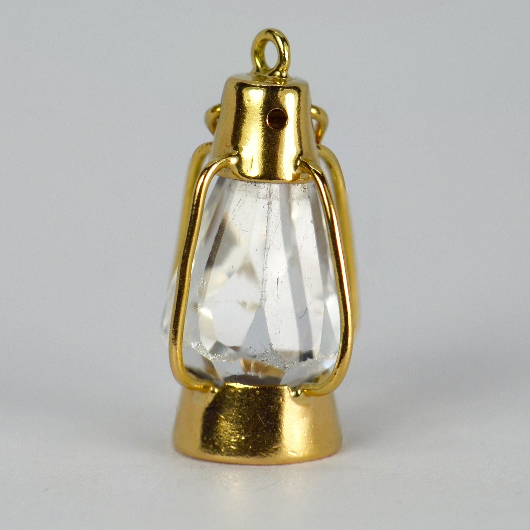 An 18 karat (18K) yellow gold charm pendant designed as a storm lantern with colourless paste glass. Unmarked but tested for 18 karat gold. 

Dimensions: 2.2 x 1.1 x 0.9 cm
Weight: 1.91 grams
