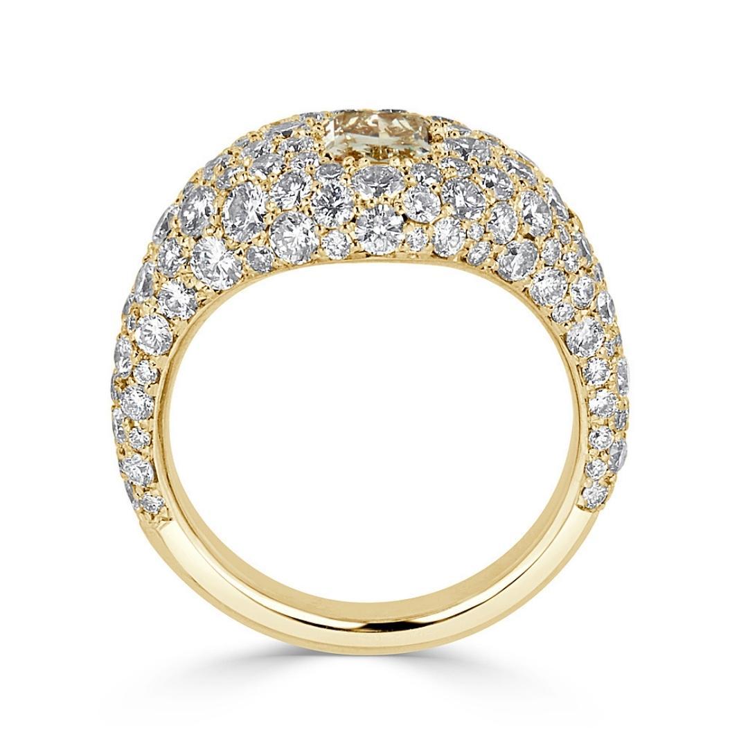 The Pave Dome Ring has a unique design with its bulge shape being highlighted by a 0.70 carat Fancy Yellow Radiant Cut Diamond surrounded by 1.10 carat diamonds, which draw undivided attention with its chic stance and sparkling stones elaborately