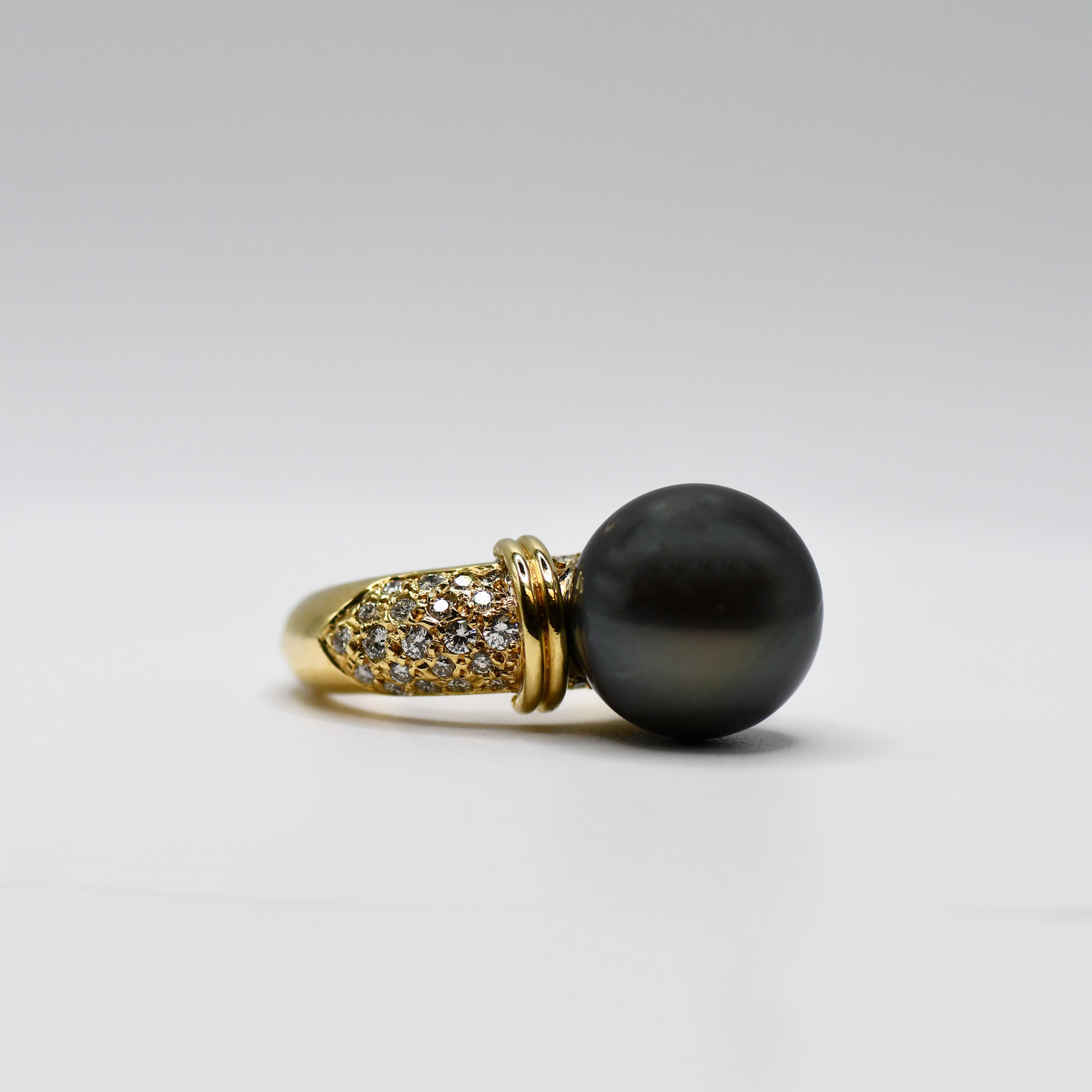 Ladies Tahitian pearl and diamond ring in 18k yellow gold setting.
Tests 18k and weighs 10.7 grams gross weight.
The black Tahitian pearl  measures 13.5mm in diameter.
It has some natural surface blemishes.
The diamonds on the sides are round