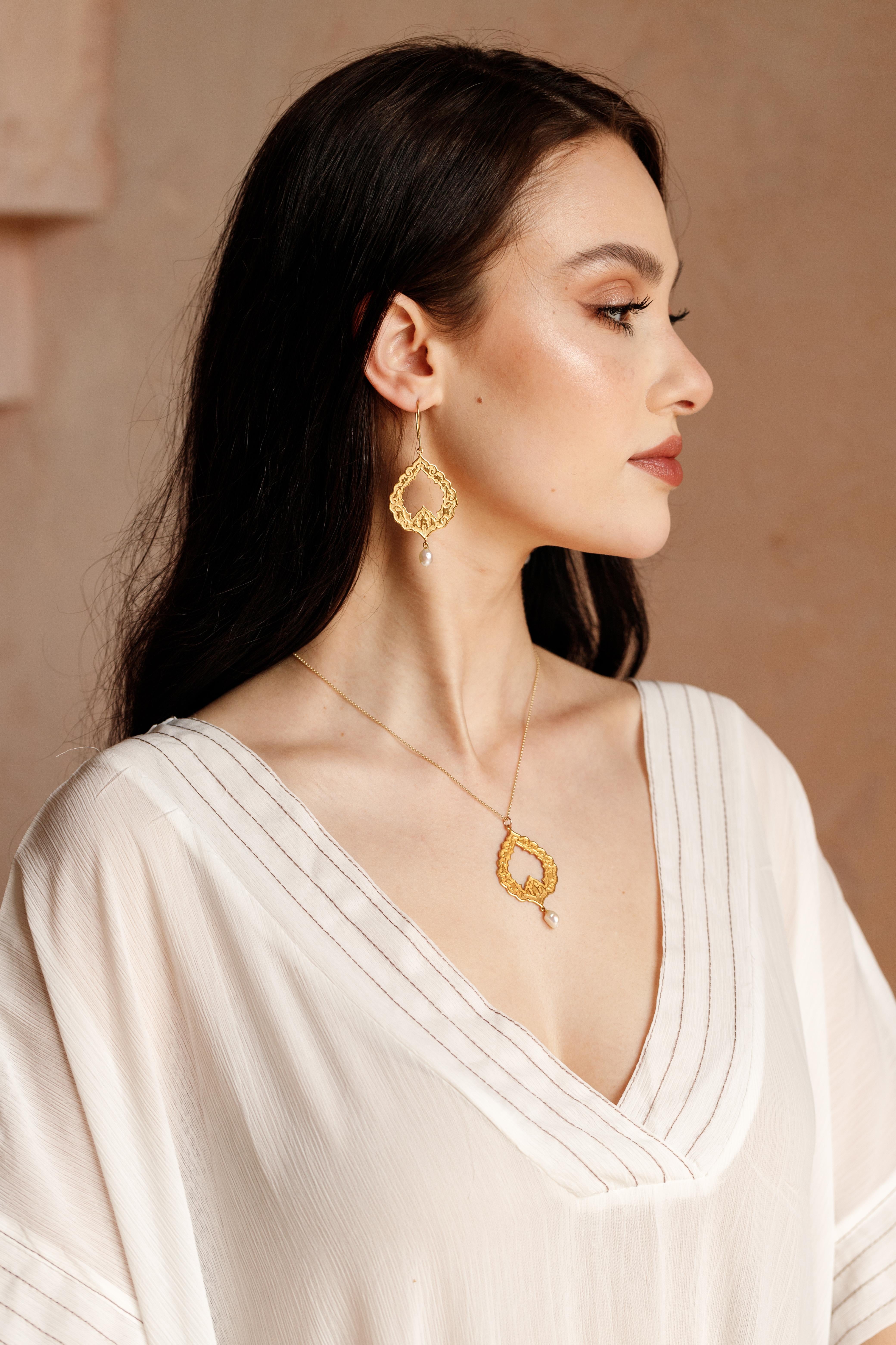 Eslimi pendant Crafted in 18K Yellow Gold and features 100% natural baroque pearl, was inspired by arabesque and Middle eastern art & architecture. This unique designer pendant is timeless and eye-catching and has delicate pattern on both sides, It