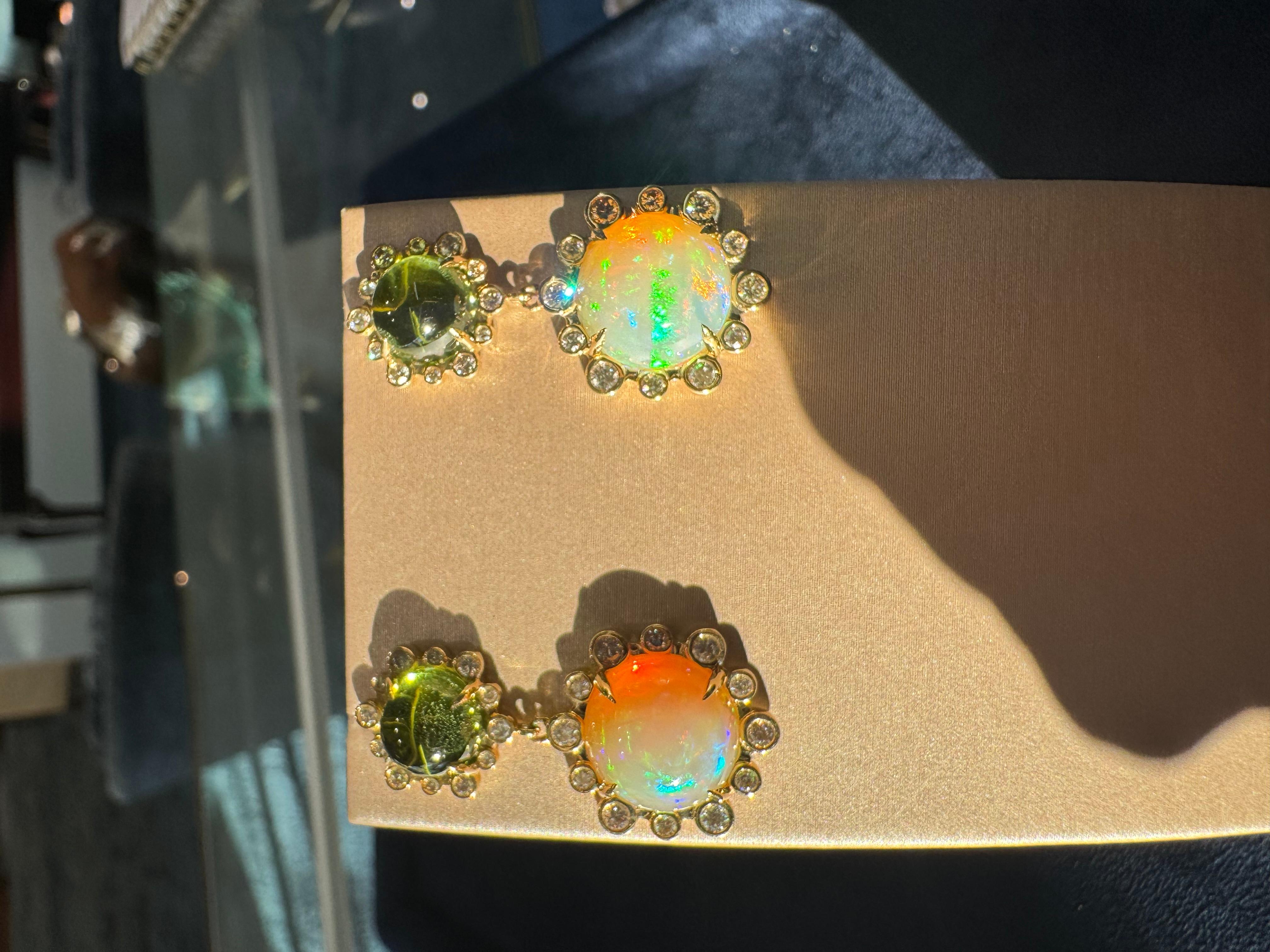 These stunning 18k yellow gold earrings feature a perfect pairing of two vibrant Peridot stones. The striking green hues of the Peridot catch the light with every movement, adding a bold yet elegant touch. Suspended beneath each stone is a beautiful
