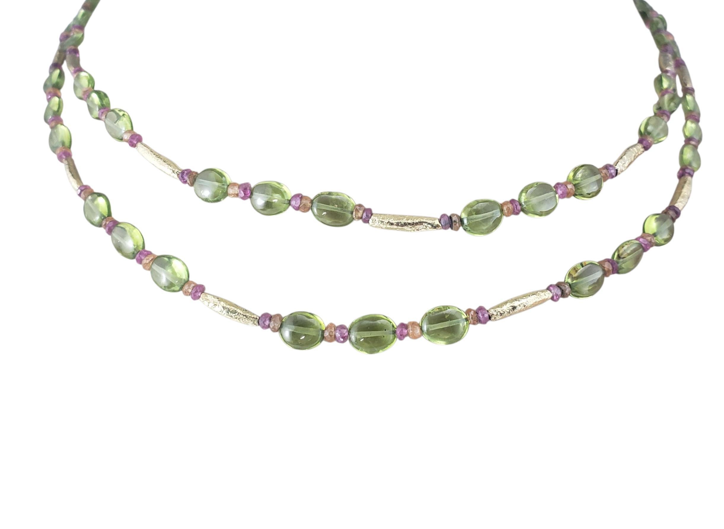 18K Yellow Gold Peridot and Pink and Orange Sapphire Toggle Necklace JAGi Certified-

This striking double row twist necklace is crafted in 18K yellow gold and features a vibrant mix of natural gemstone beads; 61 oval cut peridots, 84 natural pink