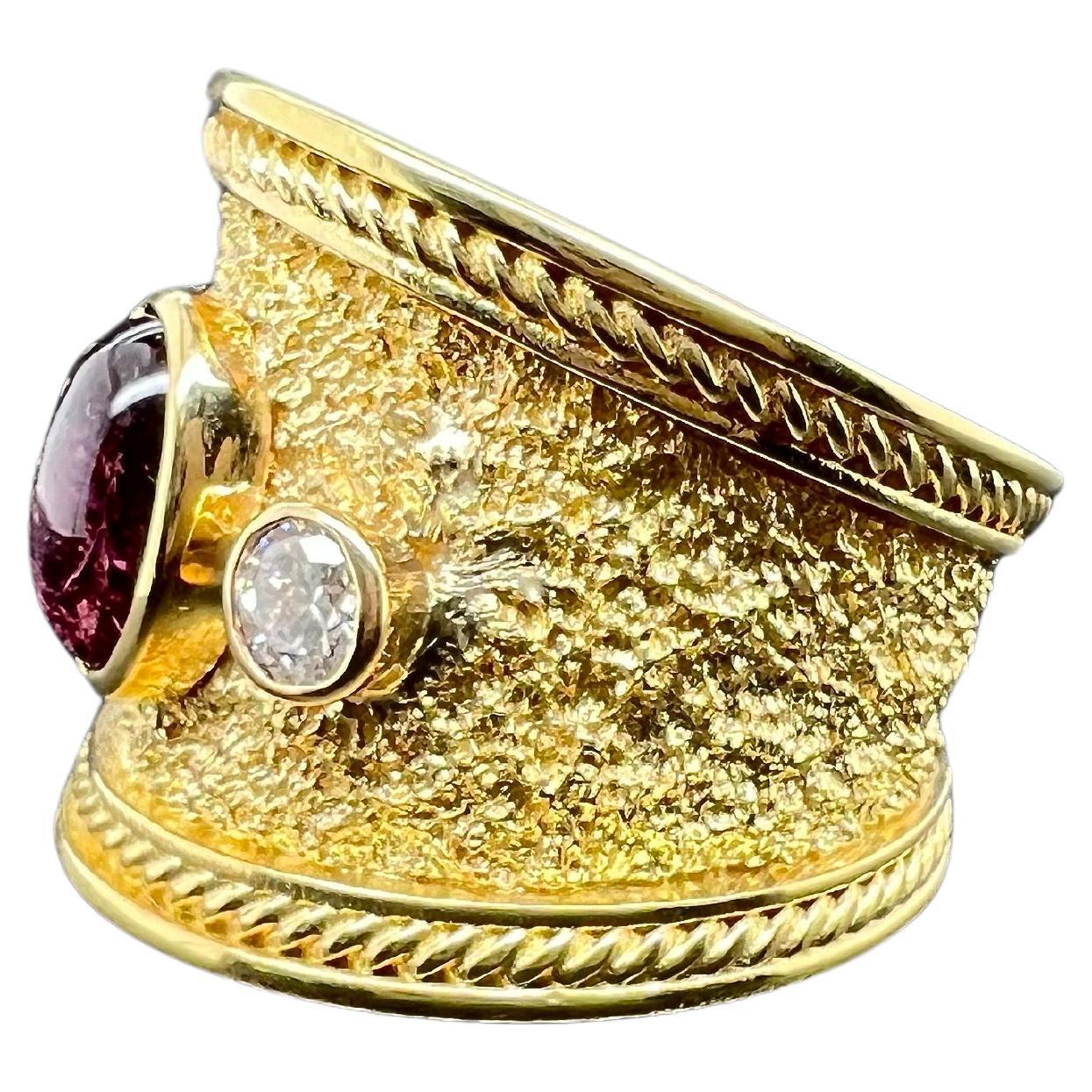 This amazing cigar band style pink cabochon tourmaline ring will be the talk of the town! The textured band offsets the illustrious round diamonds and the glowing pink tourmaline cabochon. The wide band along with the rope style texture makes the