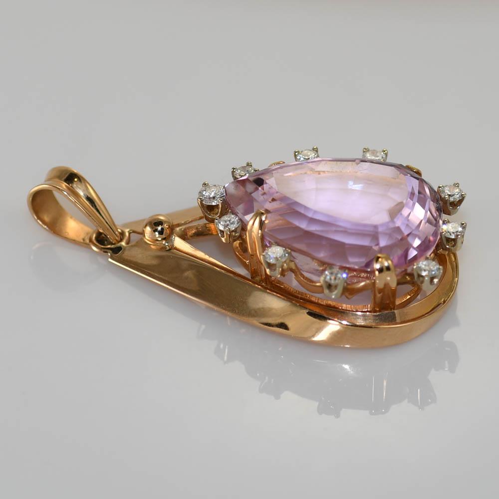 Pink kunzite and diamond pendant in 18k yellow gold setting.
The setting tests 18k and weighs 13.3 grams gross weight.
The pear shape kunzite is 25 carats, an excellent pink color.
The side diamonds are round brilliant cuts, .50 total carats, G