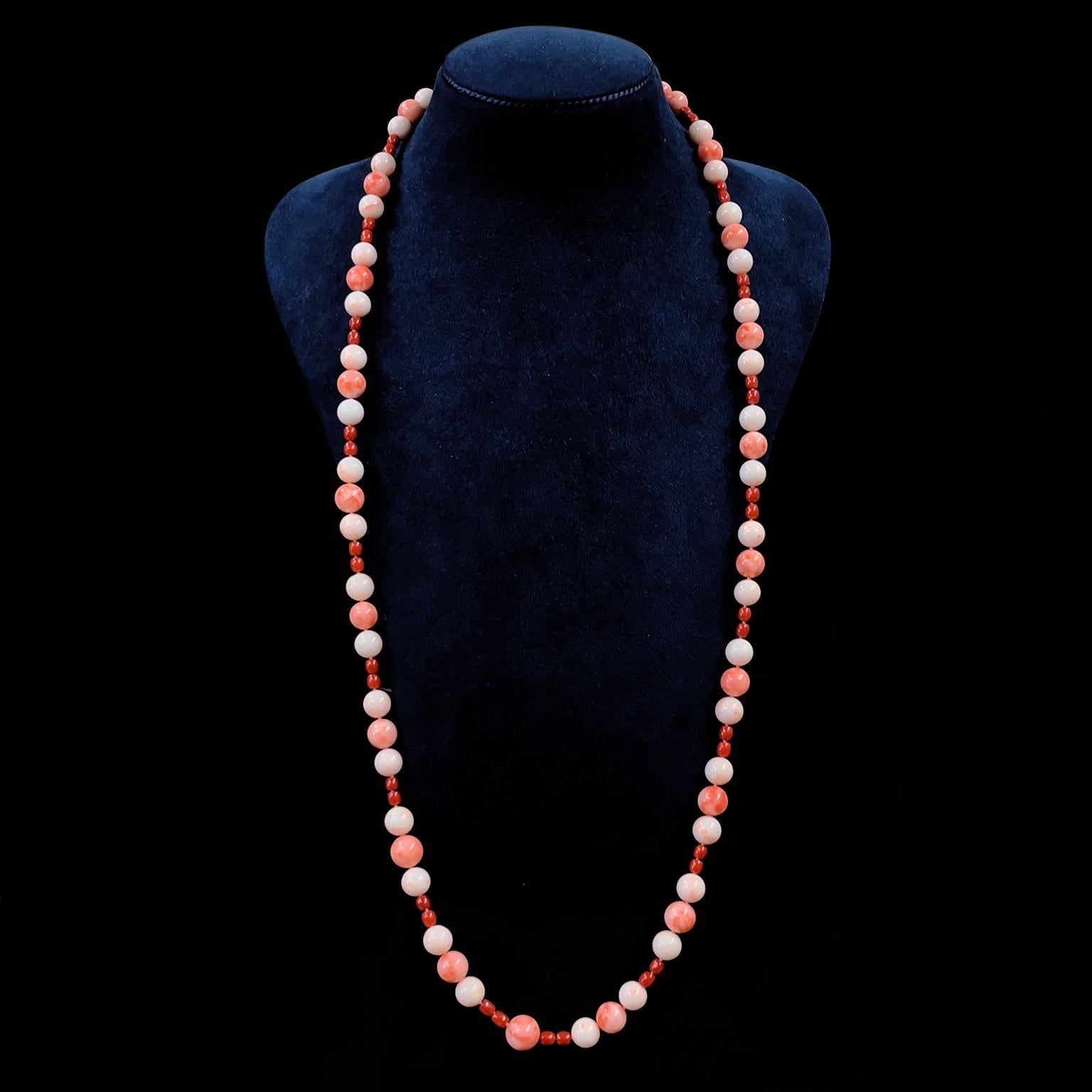 Coral of varying shades and sizes graces this beaded necklace. The pattern forms a trio of coral globes with a pink coral between two white corals, followed by a pair of small red coral beads. Each trio differs slightly from its neighbor, showcasing
