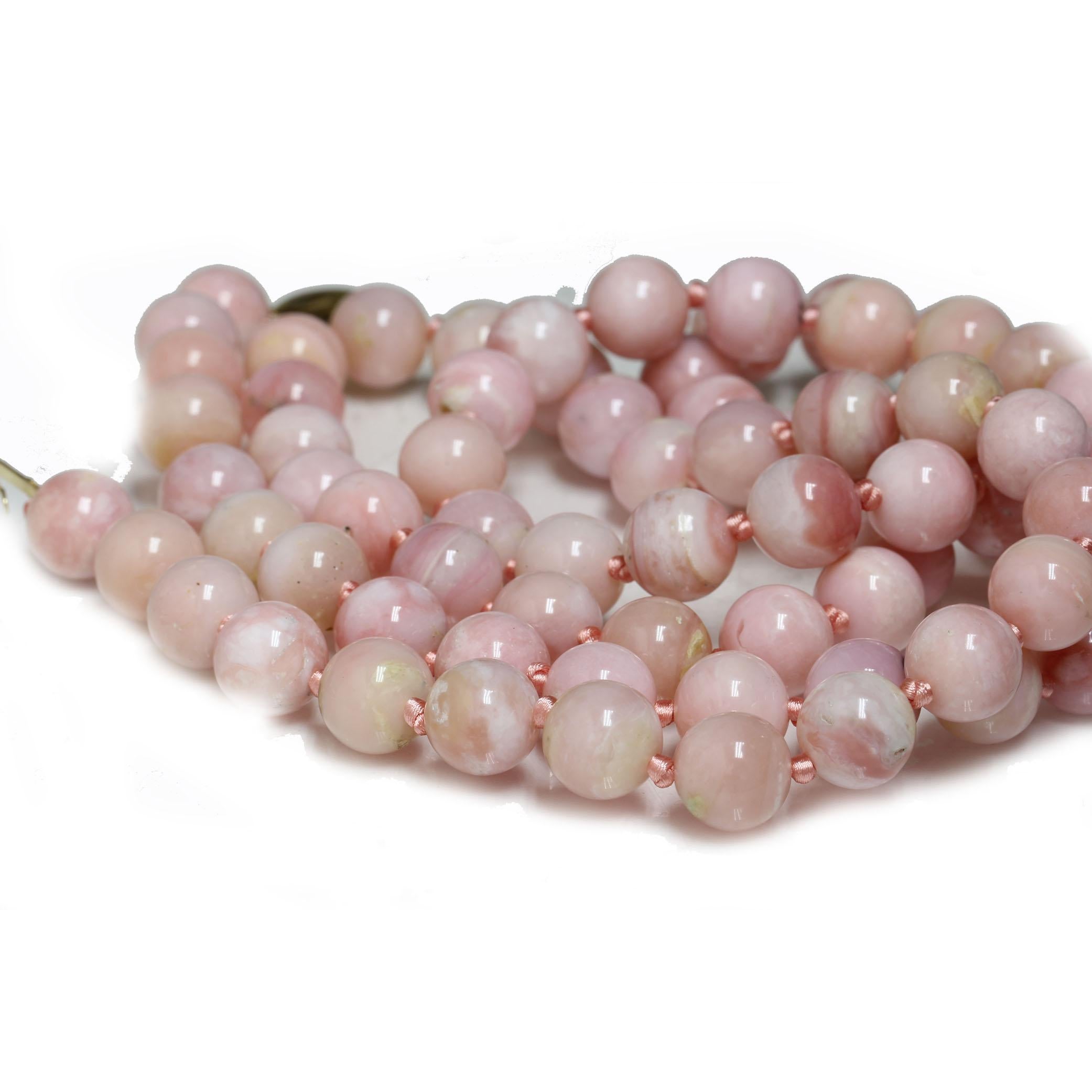 Add a gorgeous dash of color to your neckline with these stunning genuine round Pink Opal beads. A unique statement piece, but also versatile enough to wear with almost anything.  The necklace is 11mm in size hand knotted with pink silk and set with