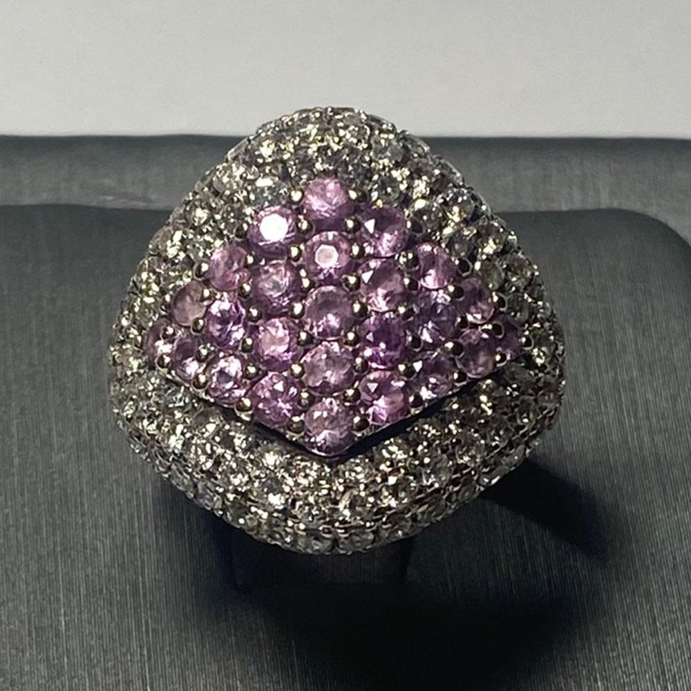 Bague de cocktail en saphir rose et diamant en or 18k, réalisée sur mesure.
La partie supérieure de l'anneau est en or blanc, la moitié inférieure en or jaune.
Estampillé 18k et pèse 12,5 grammes.
Le haut de l'anneau mesure 21 mm de large.
Les