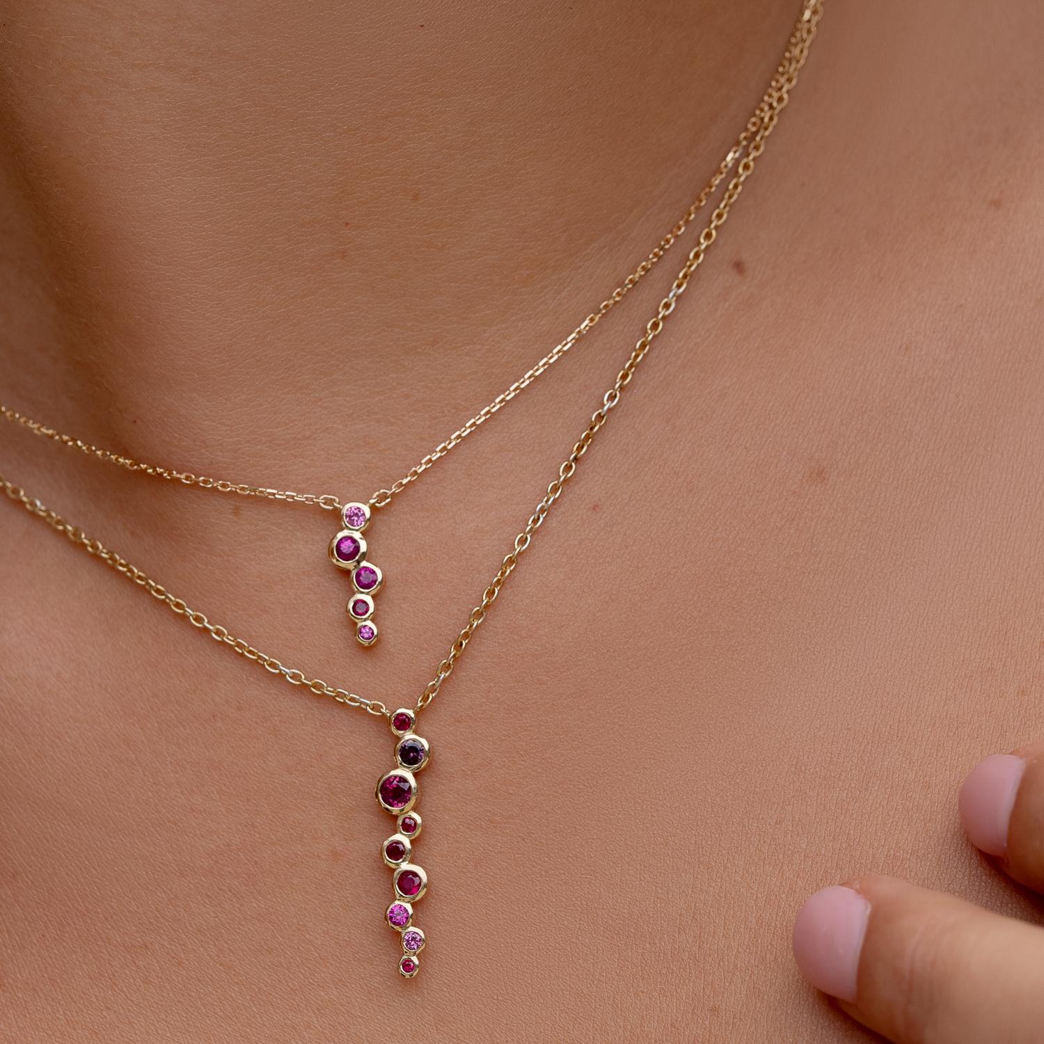 Lujosamente elaborado a mano en oro amarillo de 18 quilates, este elegante colgante Cascada presenta una delicada cascada de gemas de zafiro rosa y rubí. Estas coloridas gemas están engarzadas en una combinación ombre y suspendidas de una fina