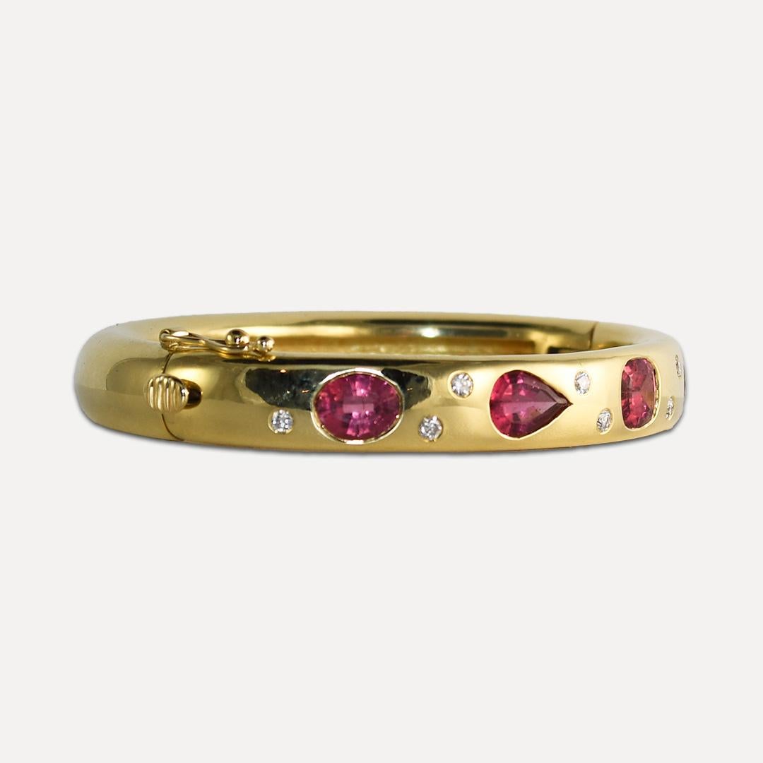 Ladies' bangle bracelet with pink tourmaline and diamonds in 18k yellow gold setting.
Tests 18k with an electronic tester and weighs 78.7 grams gross weight.
The four tourmalines have different shapes and weigh approximately 6.50 carats.
The