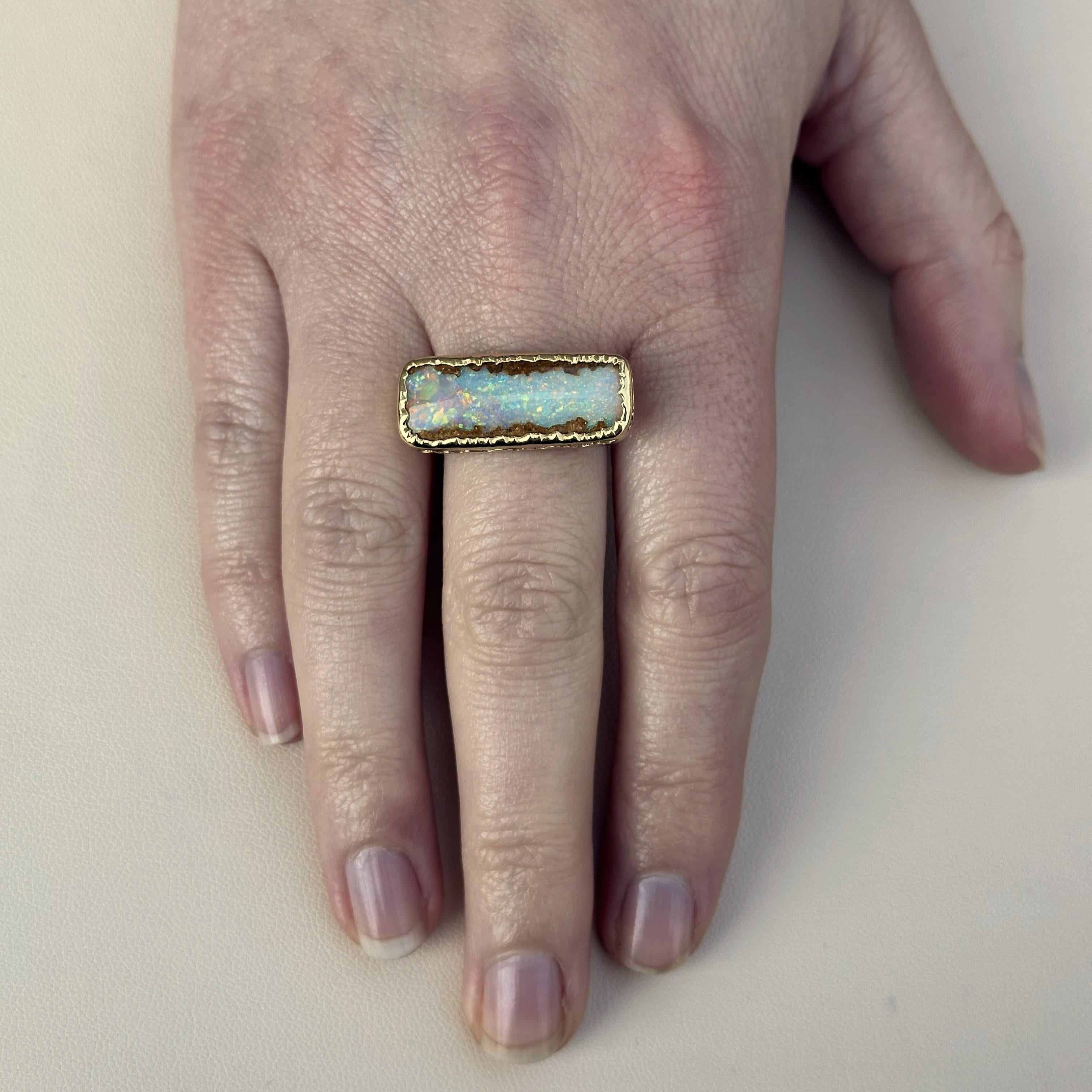 An 18k Yellow Gold ring with a bezel set 8 carat pipe-variety boulder opal. This ring was designed and made by llyn strong.