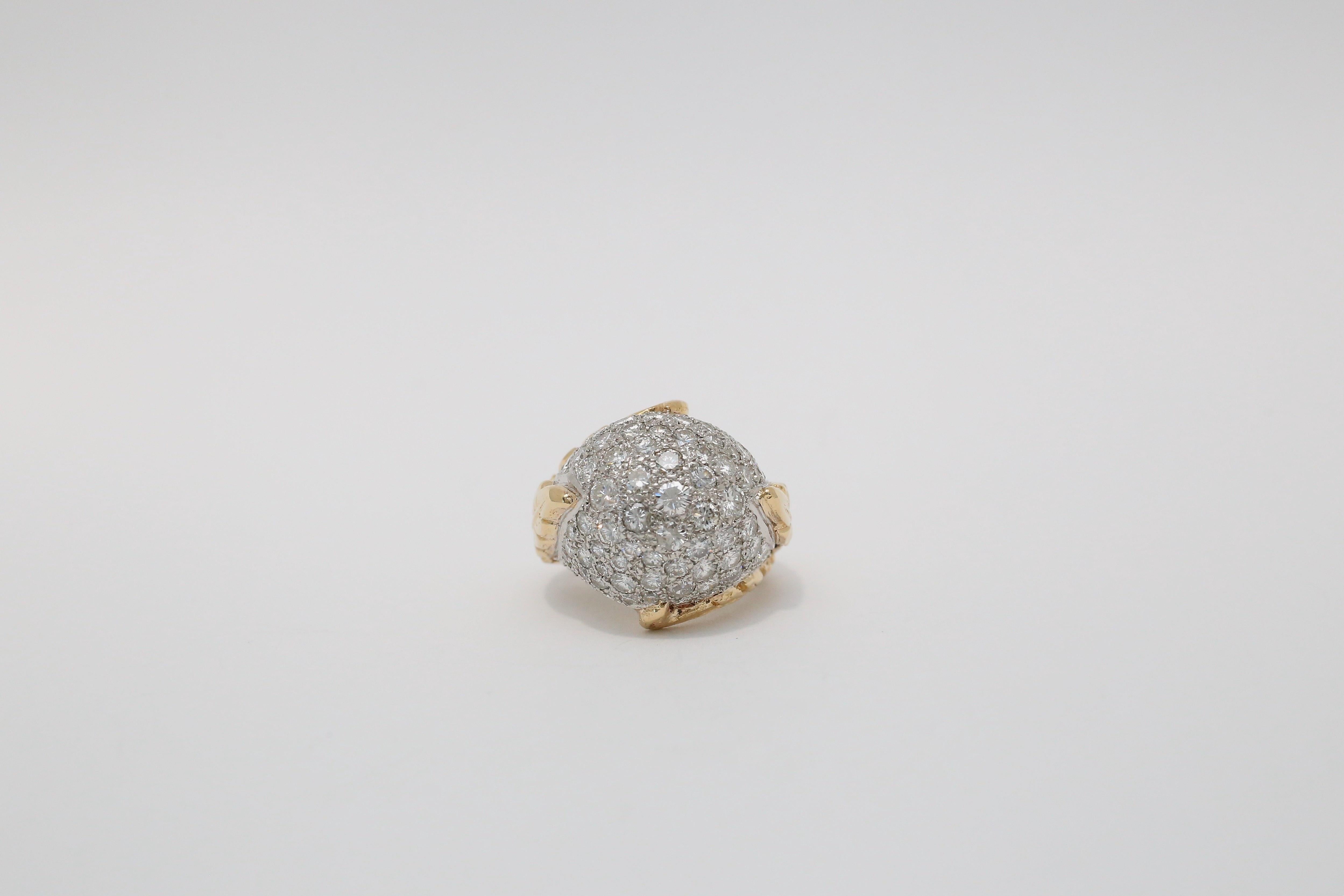 Cette étonnante bague dôme en or jaune 18 carats et platine présente un design audacieux et sculptural, incrusté d'un éventail de diamants ronds étincelants en serti pavé. Le dôme est entièrement enrobé de platine, créant une surface chatoyante qui