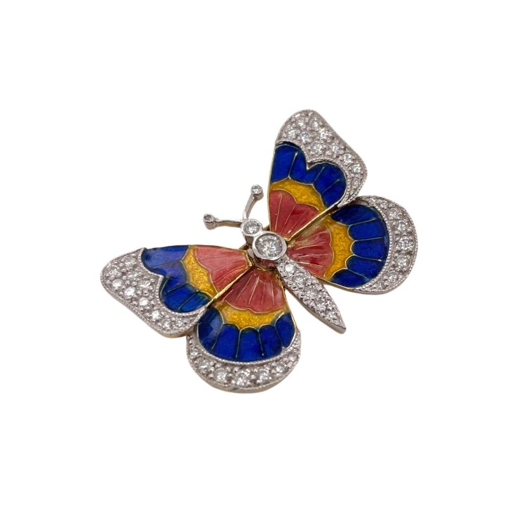 Whimsical diamond and enamel butterfly brooch in 18k yellow gold and platinum. Brooch contains 3 enamel colored sections of blue, yellow and orange creating the perfect combination for butterfly design. Butterfly body and wings are accented by round