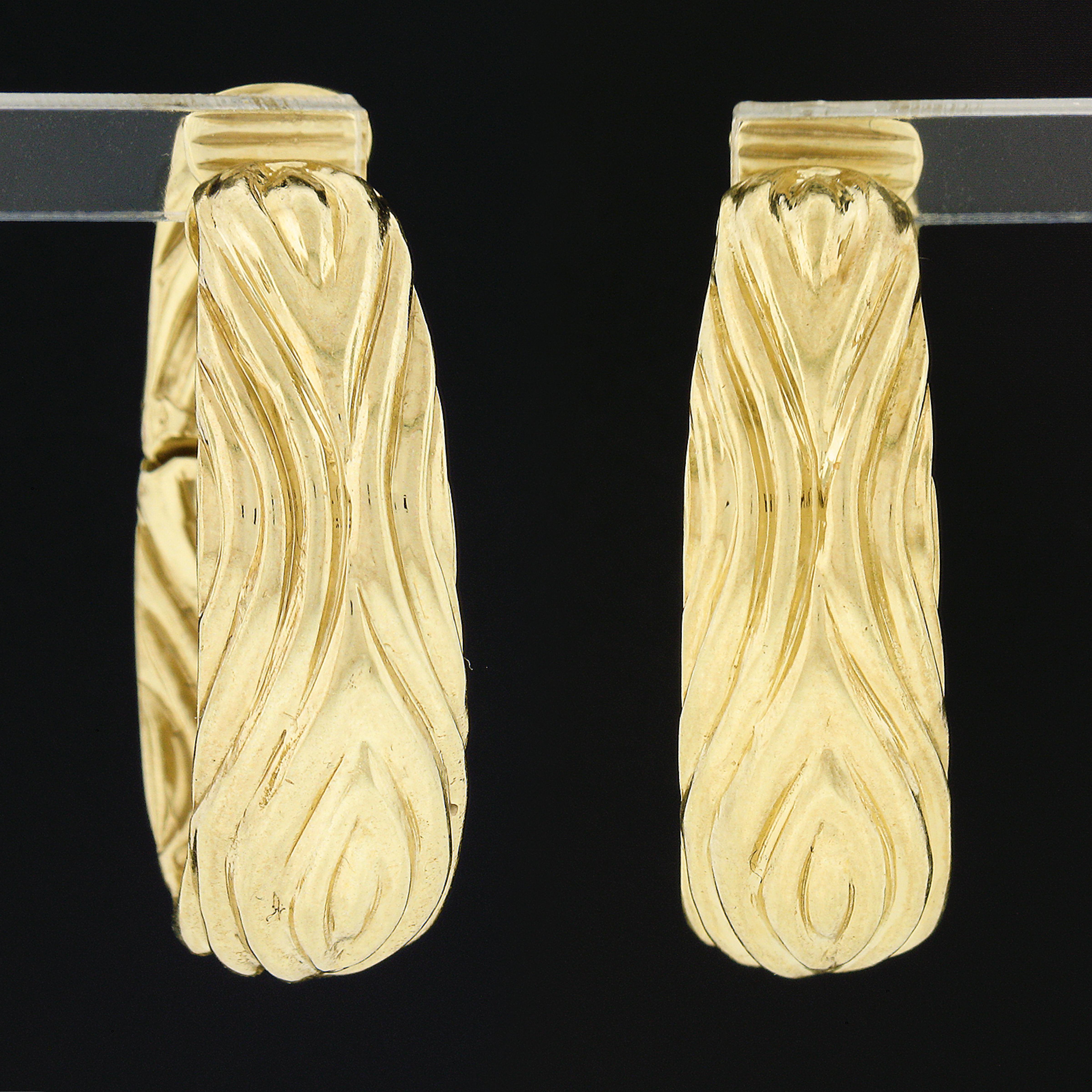 Here we have an absolutely elegant pair of hoop/huggie earrings that is crafted from solid 18k yellow gold. These bold oval shaped hoops feature a lovely sculpted pattern that gives the pair their wonderful textured look, in which runs entirely
