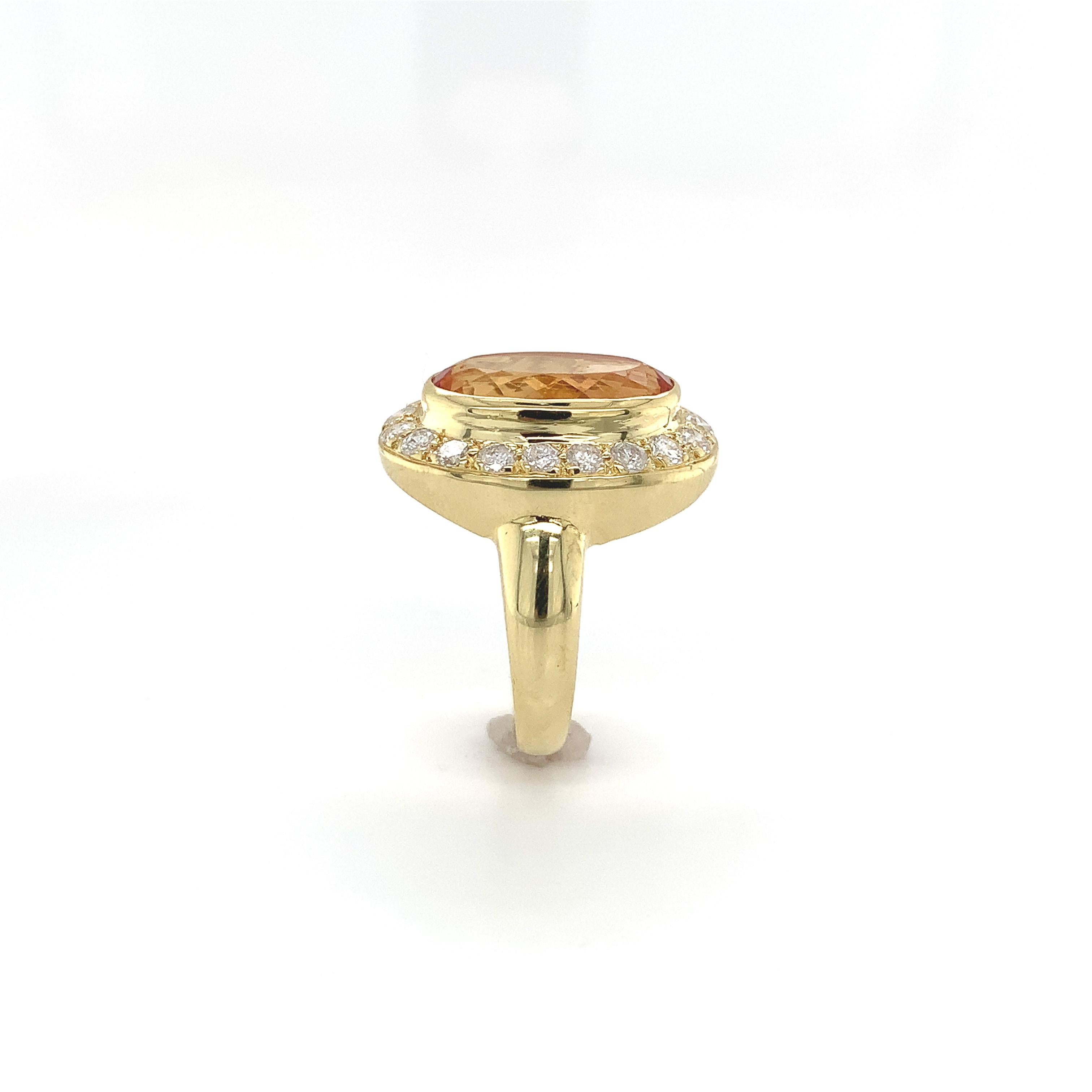 18K yellow gold precious topaz and diamond ring. The long oval precious topaz measures abut 14mm x 9mm and weighs about 5 carats. The topaz has golden yellow-orange color. There are 19 round brilliant cut diamonds weighing about .95ct total. The