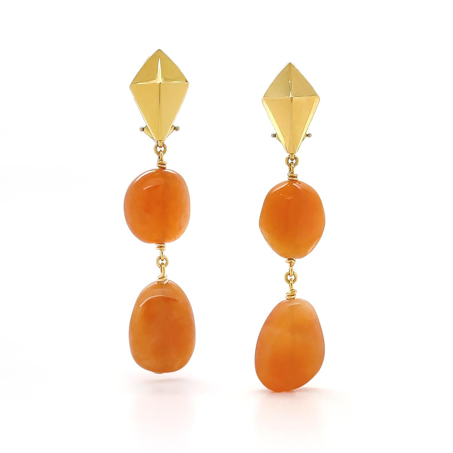 Vibrant warm tones are the essence of these drop earrings. An 18k yellow-gold kite reflects luminosity across its defined surfaces. This follows with gold links securing two individual carvings of semiprecious carnelian. Each carving in a unique