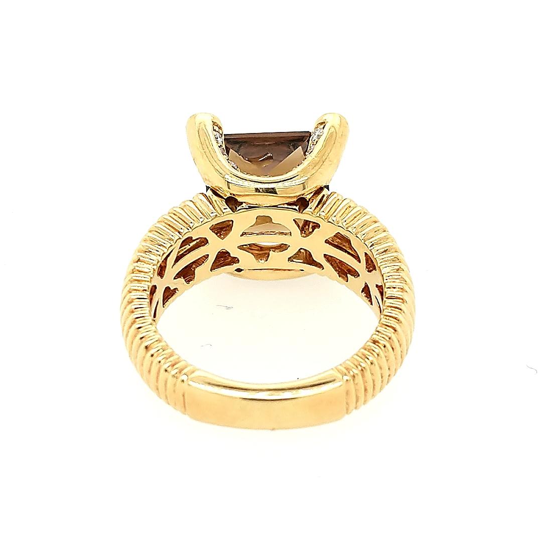 Crafted in 18k yellow gold featuring a Princess cut quartz measuring 10mm x 10mm x 5.5mm. The mounting has (42) brilliant round diamonds weighing approximately .60cttw. The ring is a size 6 3/4. 