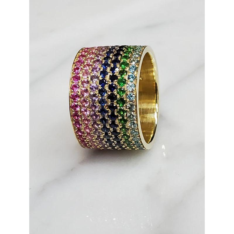 Wow, talk about a one-of-a-kind ring! 

Set in 18K Yellow Gold, this 7 row cigar ring is adorned with varying shades of pink sapphires, blue  sapphires, tsavorites, blue zircon, and purple sapphires. The ring is 12.8mm wide and is currently sized at