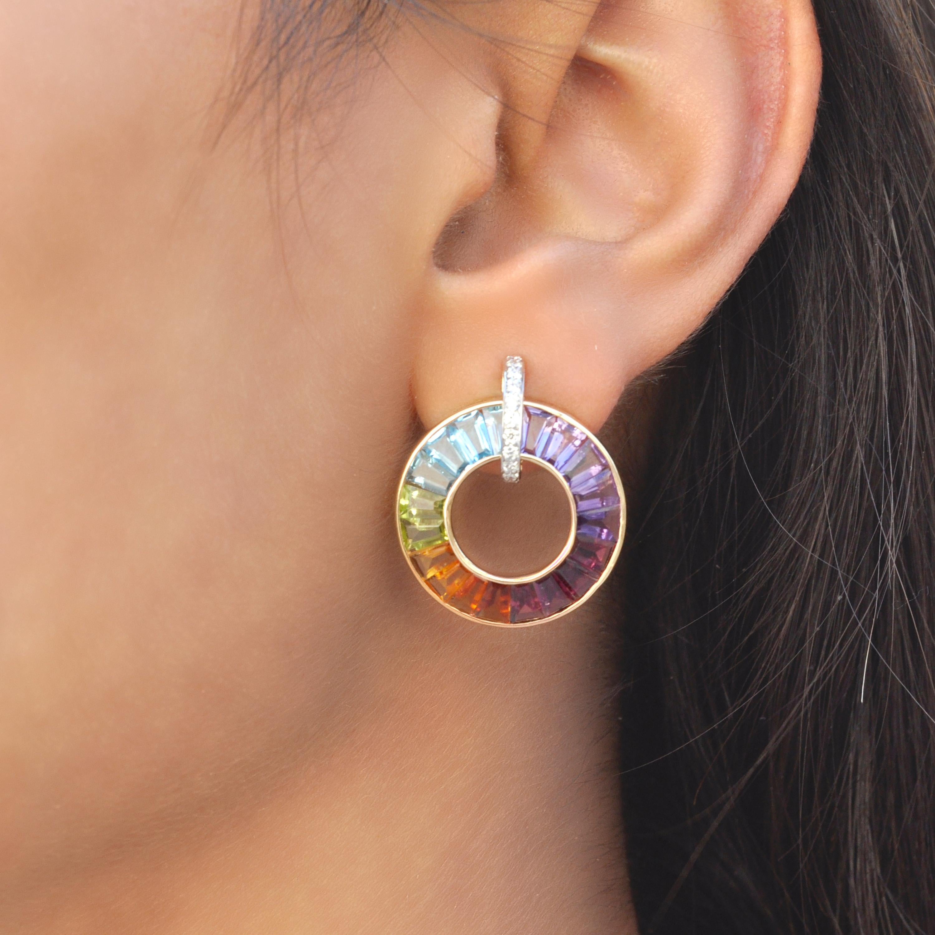 Das sind unsere 18-karätigen Goldohrringe mit Regenbogensteinen und Diamanten, ein Fest der leuchtenden Farben und des unbestreitbaren Glamours. Diese aus luxuriösem 18-karätigem Gold gefertigten Ohrringe sind mit einem fesselnden Kreis versehen,