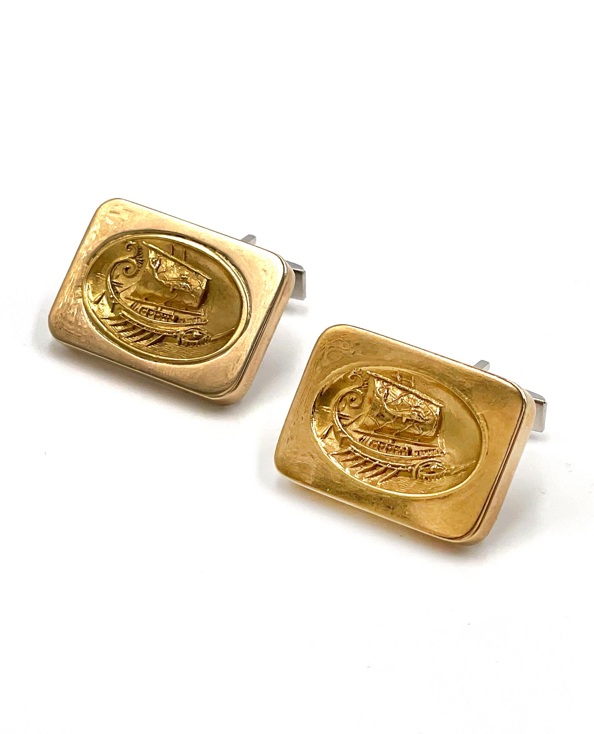 Preowned pair of 14K yellow gold cufflinks with high karat gold inset. The oblong shaped links measure
26.0x18.3mm. The centers are inset with a concave oval with a raised Viking motif.