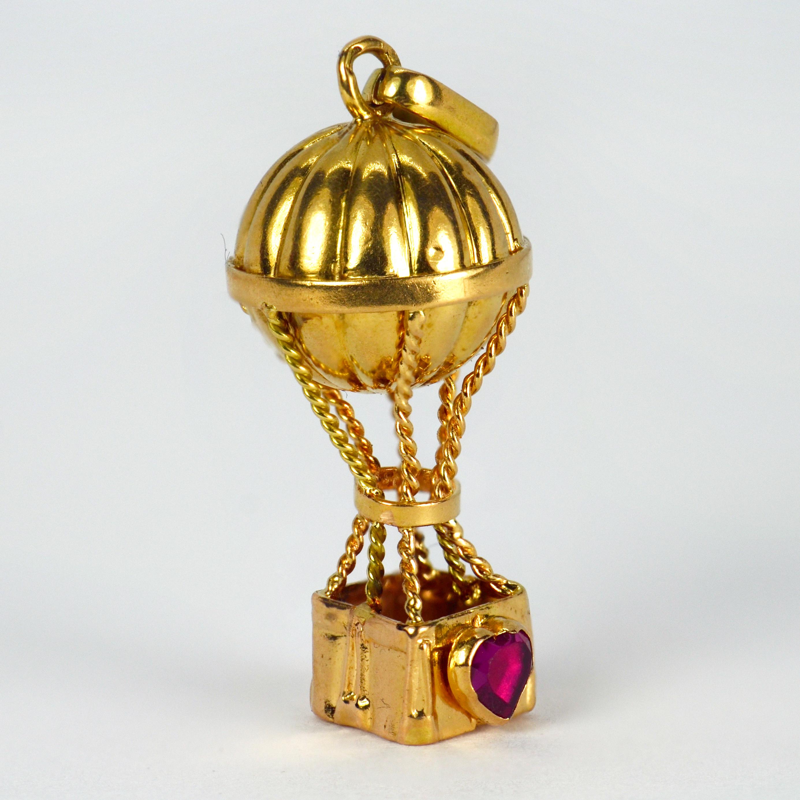 An 18 karat (18K) yellow gold charm pendant designed as a hot air balloon with a red ruby love heart to one side of the basket. Stamped with the French import marks for 18 karat gold.

Dimensions: 2.8 x 1.3 x 1.3 cm (not including jump ring)
Weight: