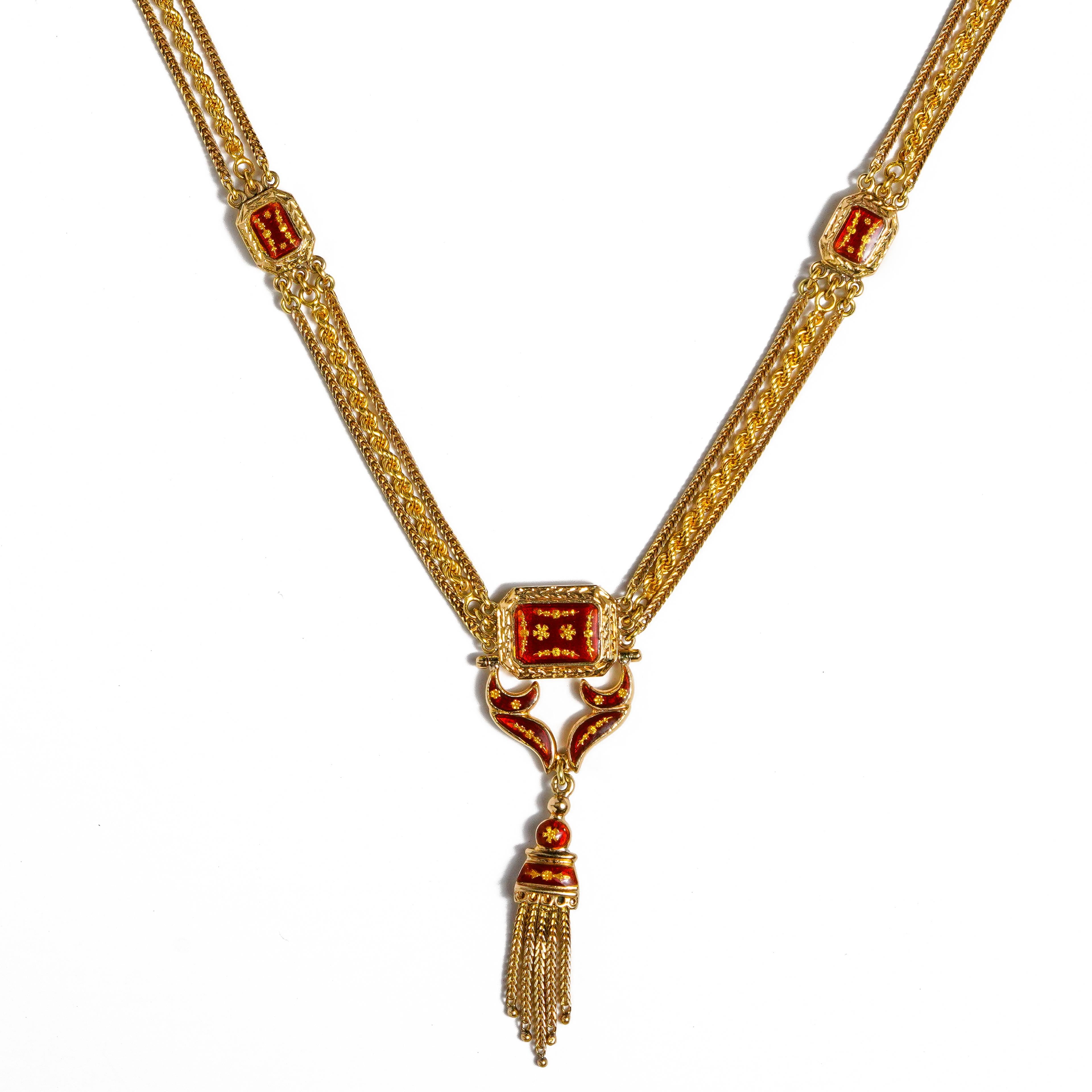 This necklace is crafted in yellow gold  with red enamel stations on one side and blue enamel stations on the other side.  The necklace has 3 chains consisting of rope and snake motif.  The necklace is 21 inches in length including the tassel.  The