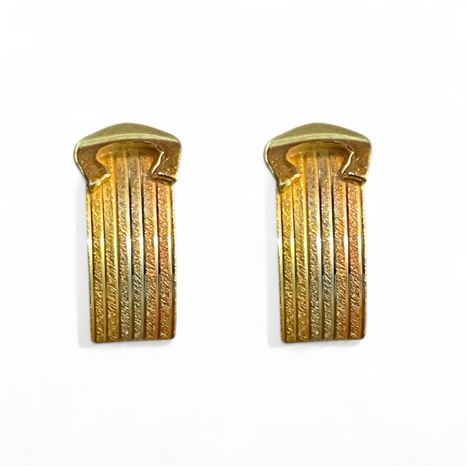 These stunning 18K yellow gold earrings feature a ribbed texture with curved details that exude a sleek and timeless elegance. Reflecting a minimalist style popularized in the late 20th century, these earrings are both understated and sophisticated.