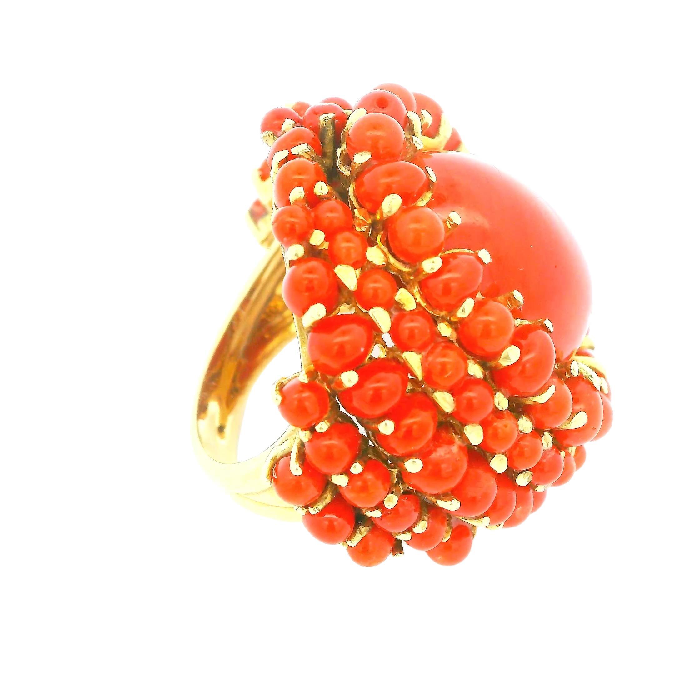 Cette bague de cocktail en corail présente une pièce centrale en corail orange vibrant, sertie d'or et ornée d'un ensemble de perles de corail plus petites.

Bague taille 5.5

Poids total 19,6 g

Origine : Italie

ID interne : 8851