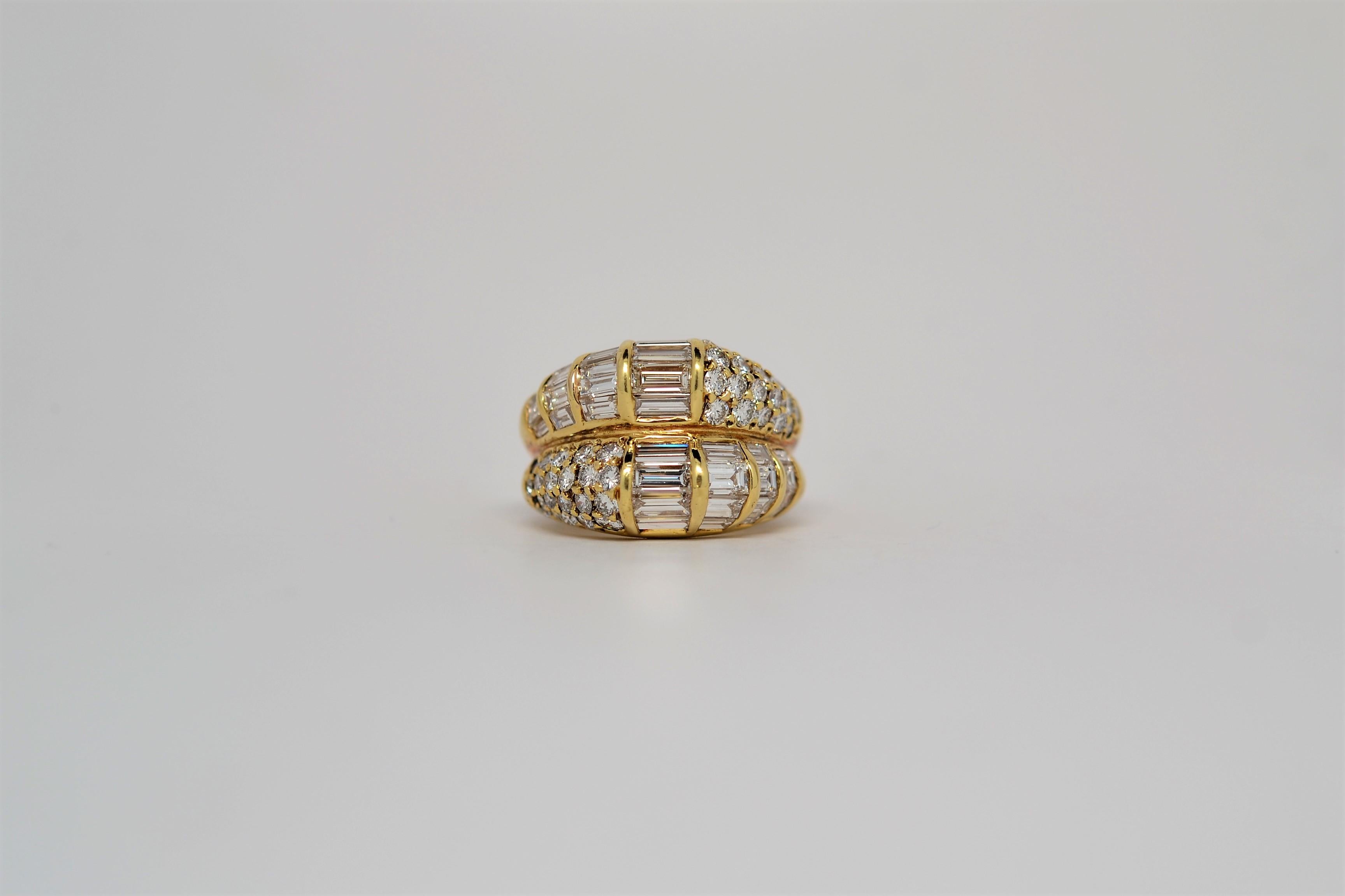A handmade and very unique ladies' ring set in 18K Yellow Gold. This ring is a two row design with a domed layout of Baguette Diamonds and Round Brilliant Cut Diamonds. Finely crafted channel settings arrange the Baguette Diamonds in domed fashion