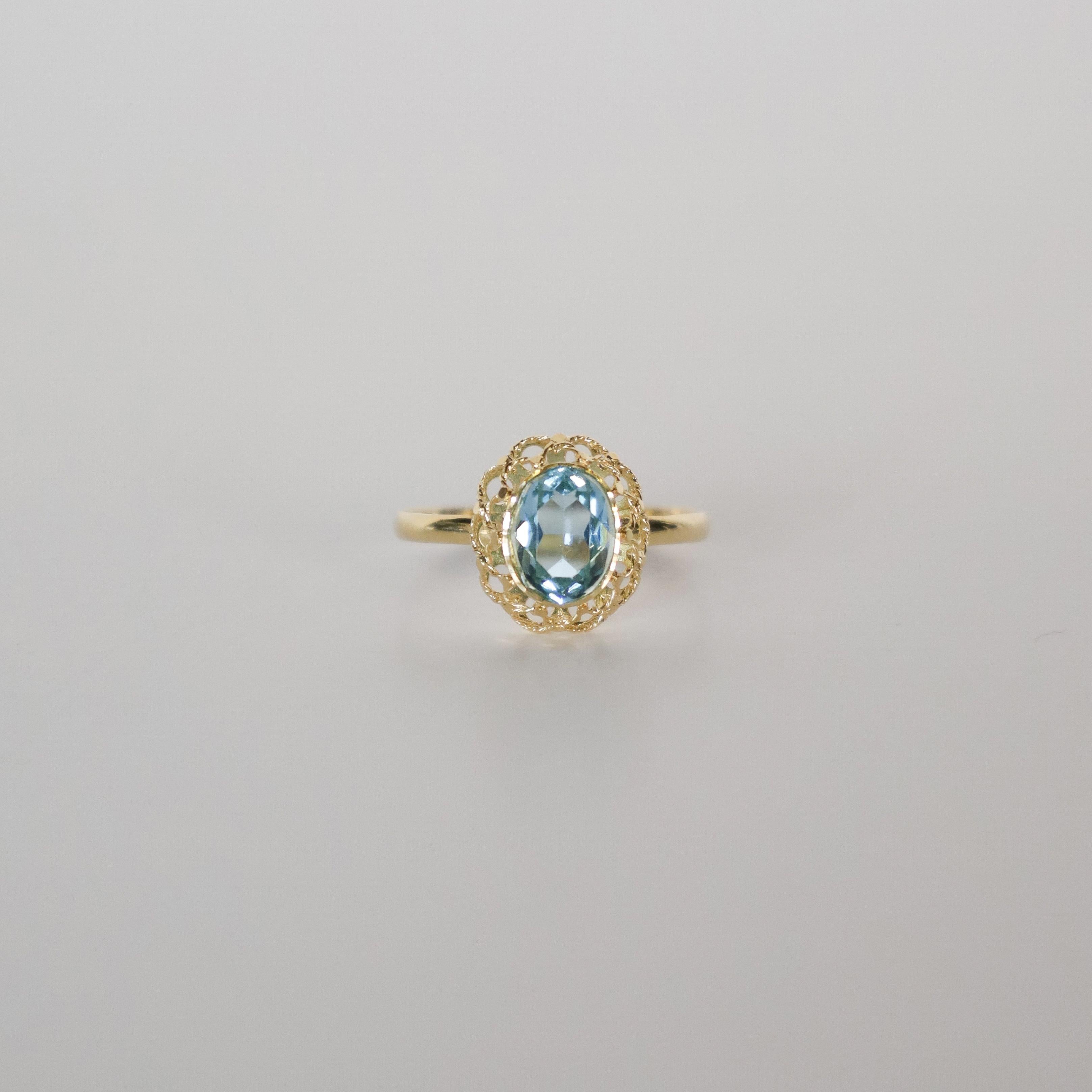 Erhöhen Sie Ihre Schmucksammlung mit diesem exquisiten Ring aus 18-karätigem Gold, der einen brillanten, natürlichen Blautopas mit den Maßen 8 mm x 6 mm enthält. Das reiche Goldband, gepaart mit dem leuchtenden Topas, ist ein klassisches und