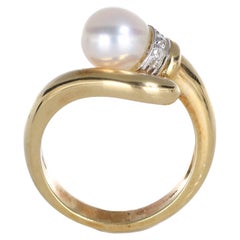 Anello in oro giallo 18k con perla centrale e castone di diamanti incastonati