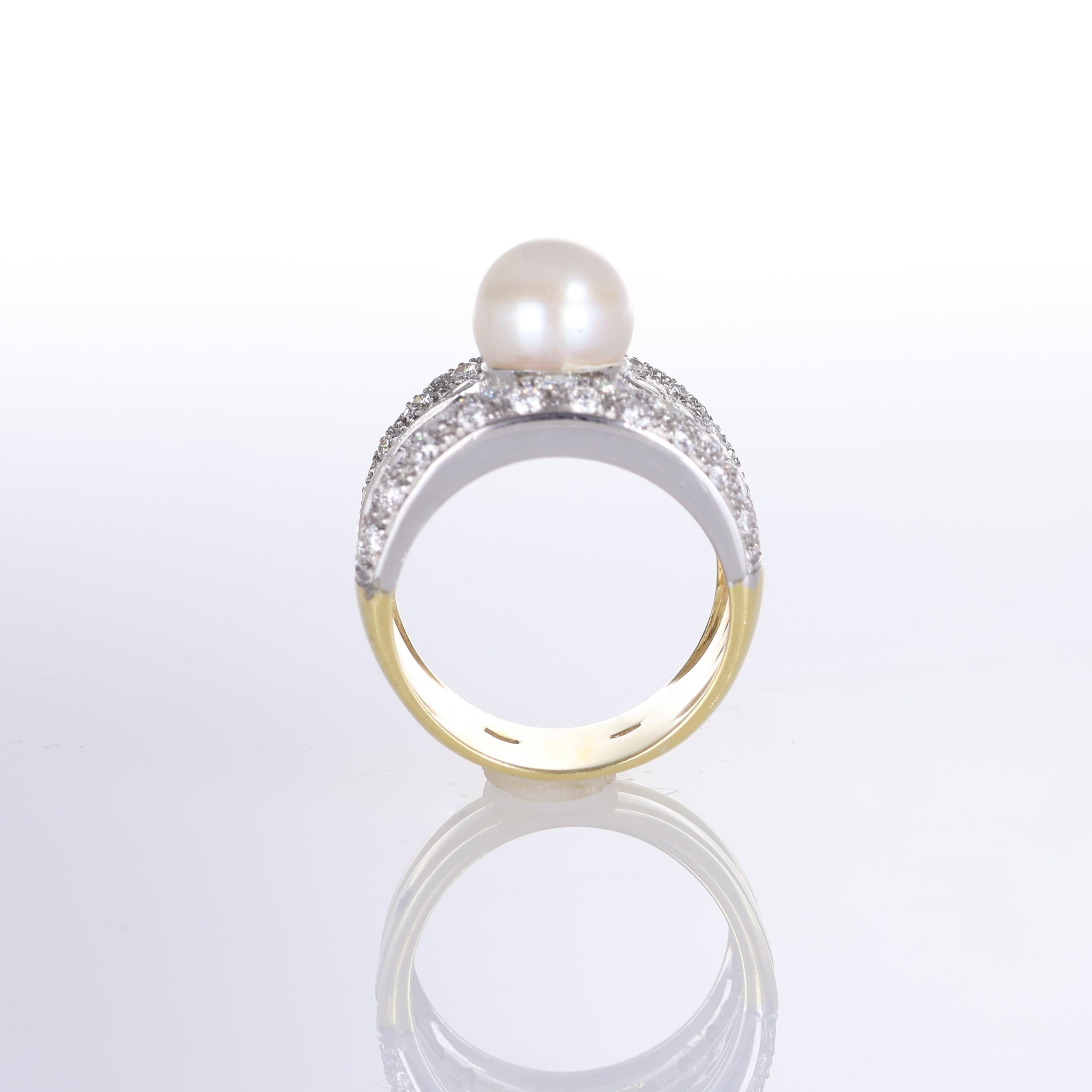 An exquisite 18k yellow gold ring featuring a luminous central pearl framed by an intricate pavé diamond weave. The elegant crossover design is adorned with 1.55 carats of brilliant-cut diamonds, enhancing the ring’s luxurious appeal. A bold yet