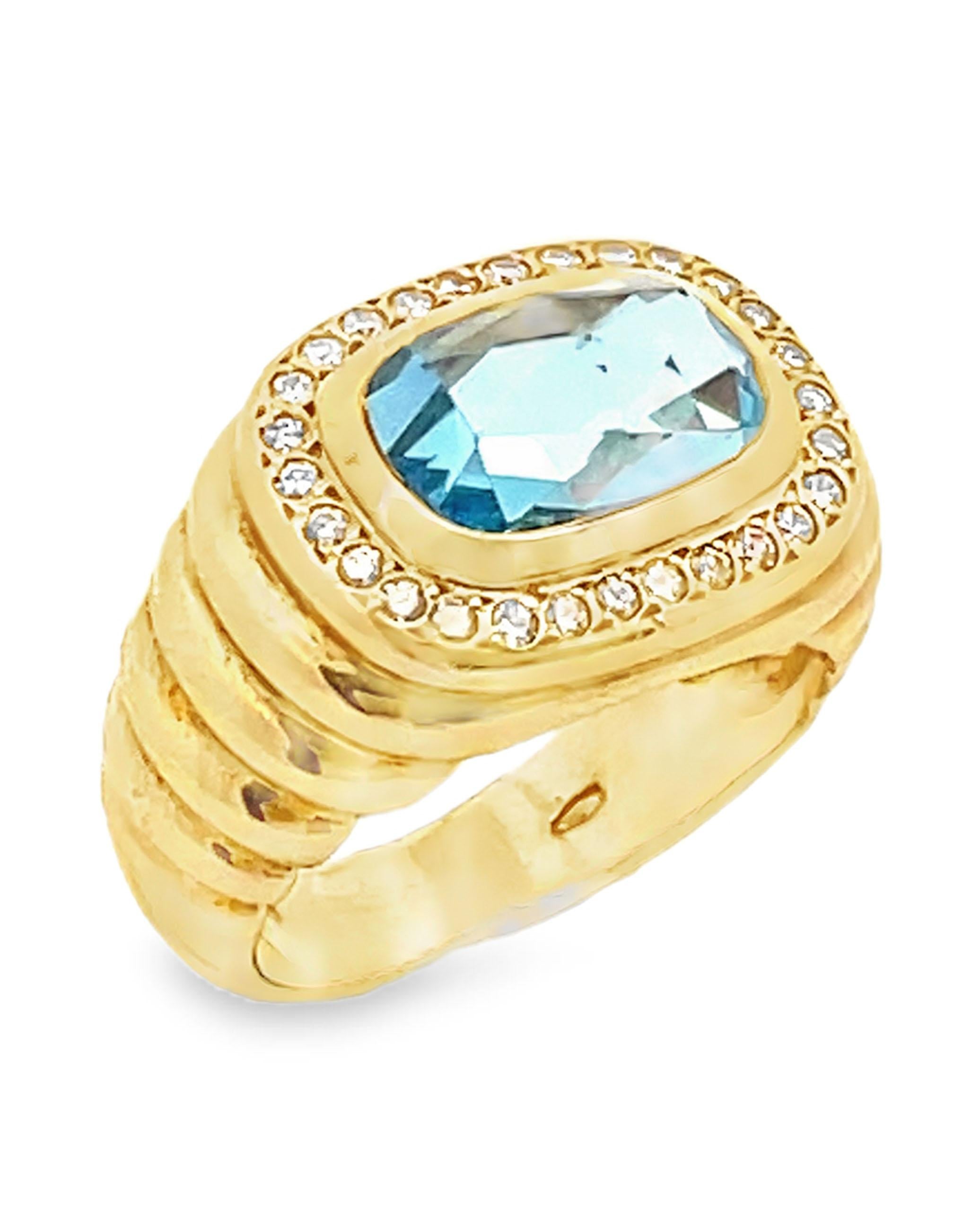 Preowned 18K yellow gold ring with 28 round faceted diamonds weighing approximately 0.45 carat total and one center blue topaz set East-West.

- Finger size 5.5