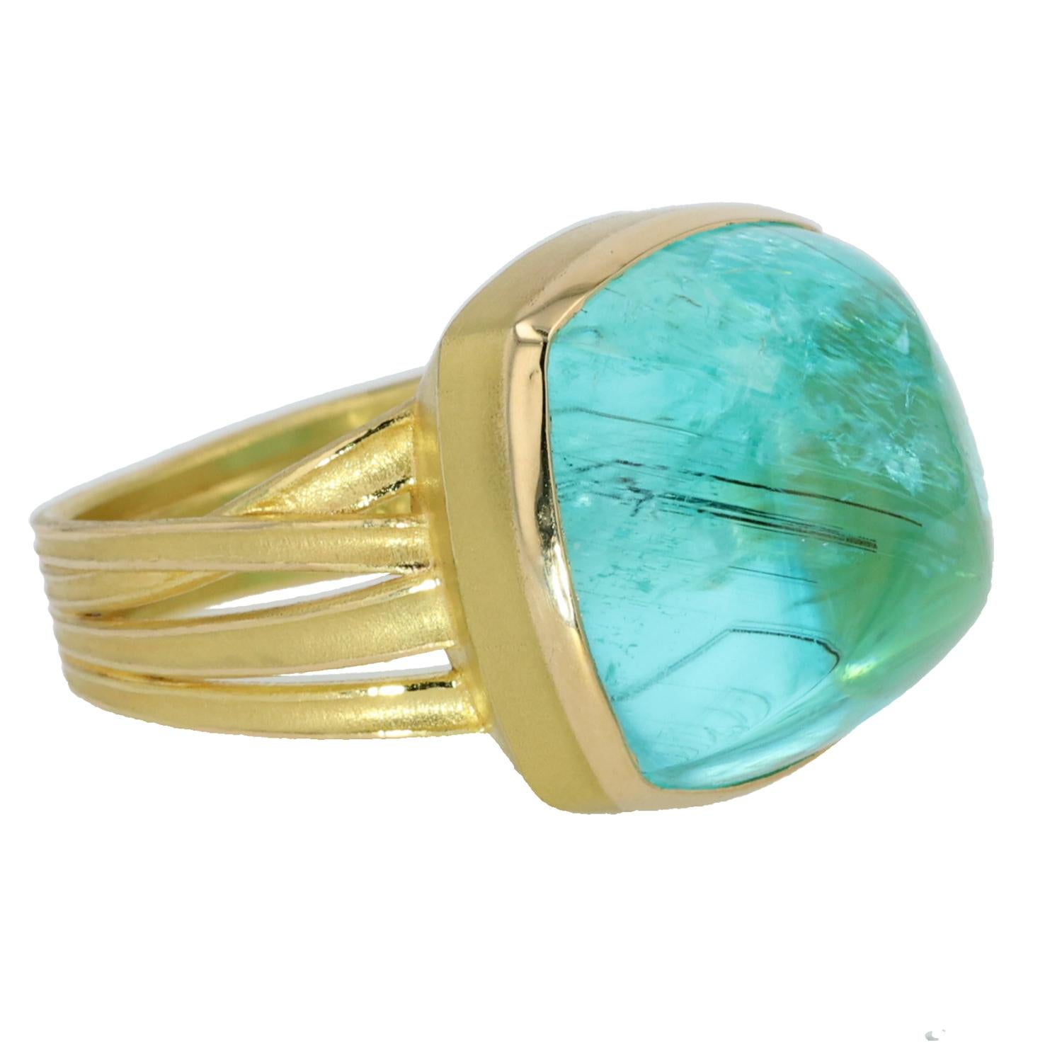 Experience the extraordinary with this captivating 18K yellow gold ring by Barbara Heinrich, featuring a stunning 26.20-carat cushion-shaped Mozambique Paraiba tourmaline cabochon. The large, vibrant tourmaline, with its enchanting teal hue, is the