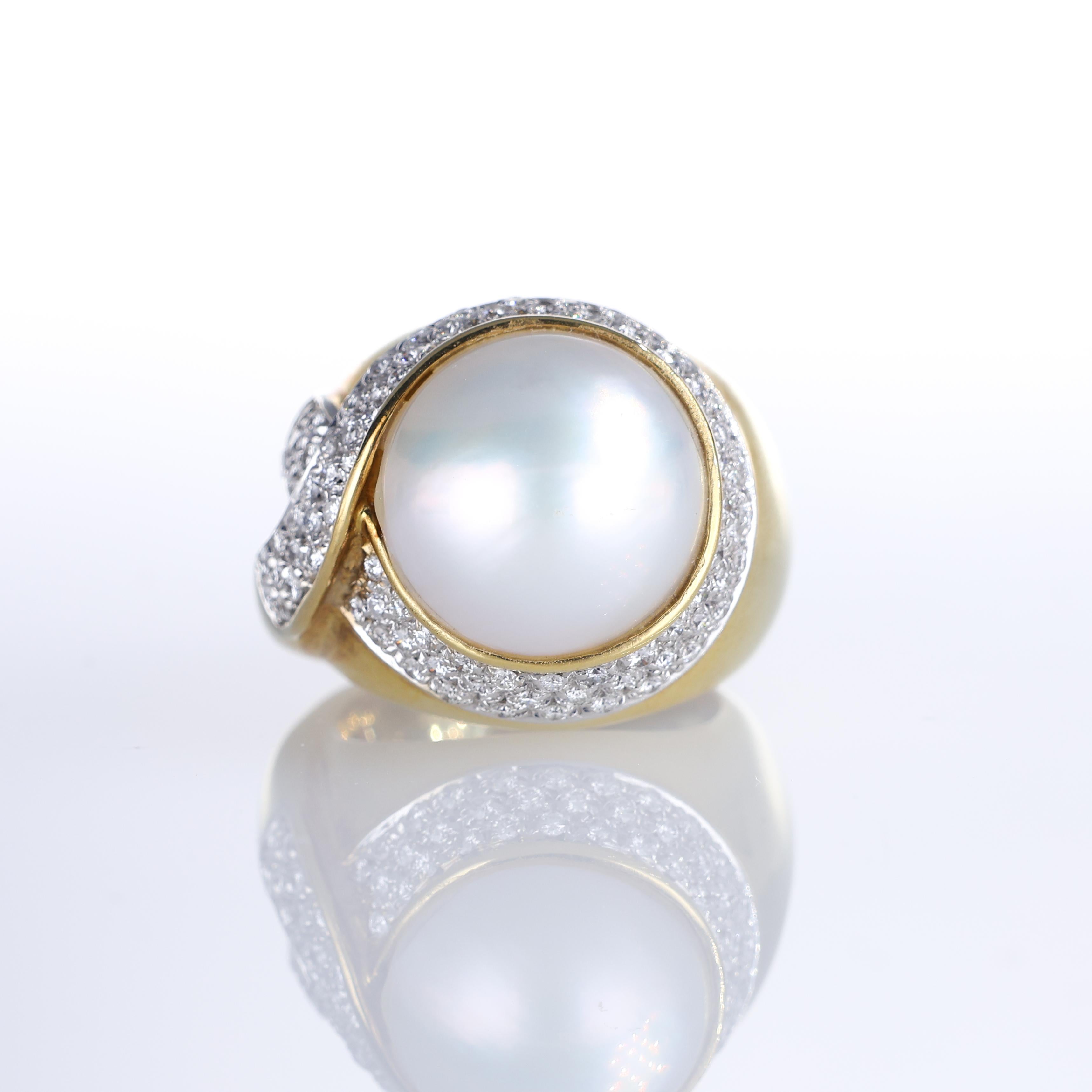 An elegant 18K yellow gold ring featuring a luminous pearl set within a sweeping pavé of brilliant-cut diamonds totaling 0.47 carats. The harmonious blend of warm gold and the sparkle of diamonds enhances the pearl’s natural radiance. A statement