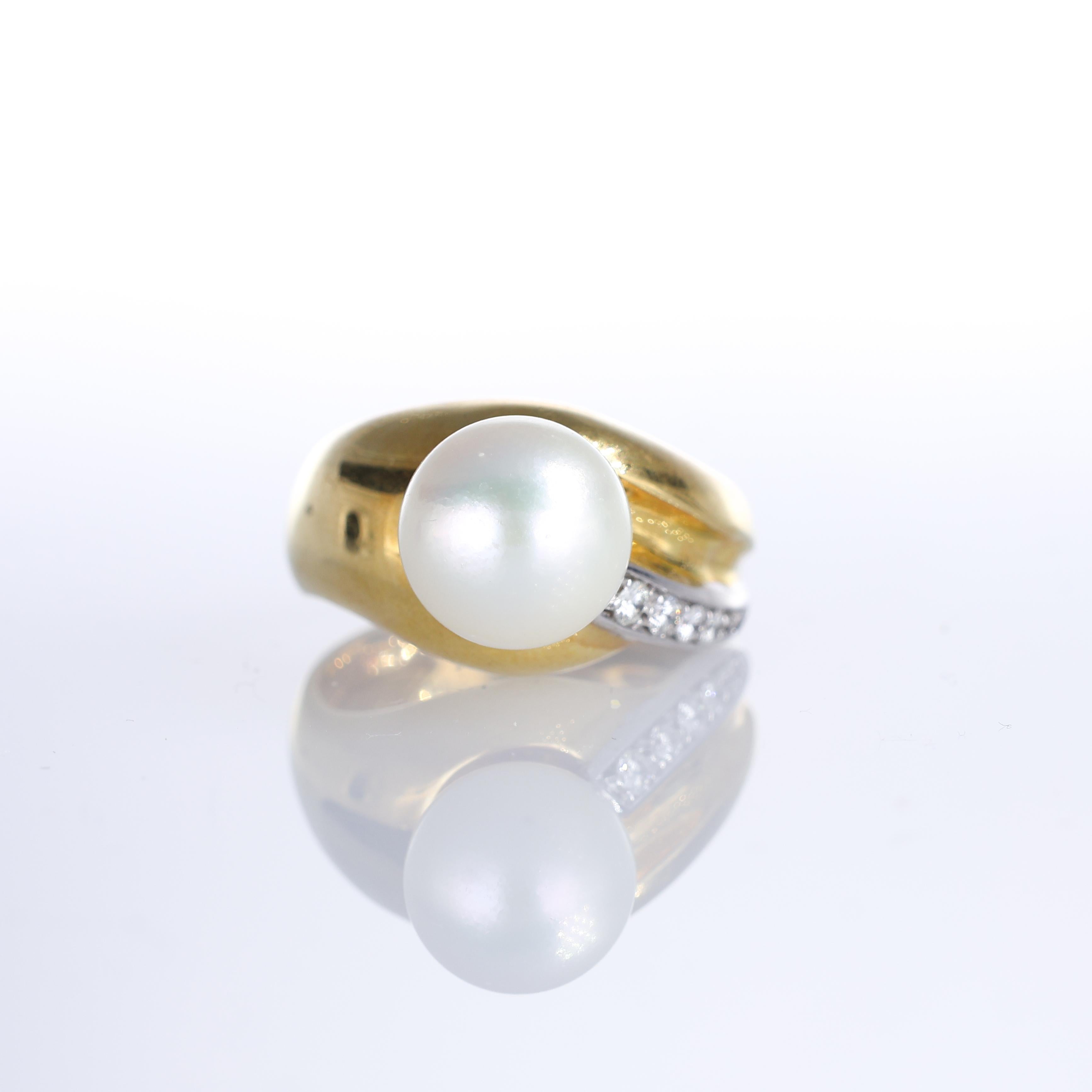 An 18K yellow gold ring with a luminous central pearl, accentuated by a single row of brilliant-cut diamonds totaling 0.18 carats. The fluid design of the gold setting adds an organic elegance, making this a refined yet contemporary piece.

Key