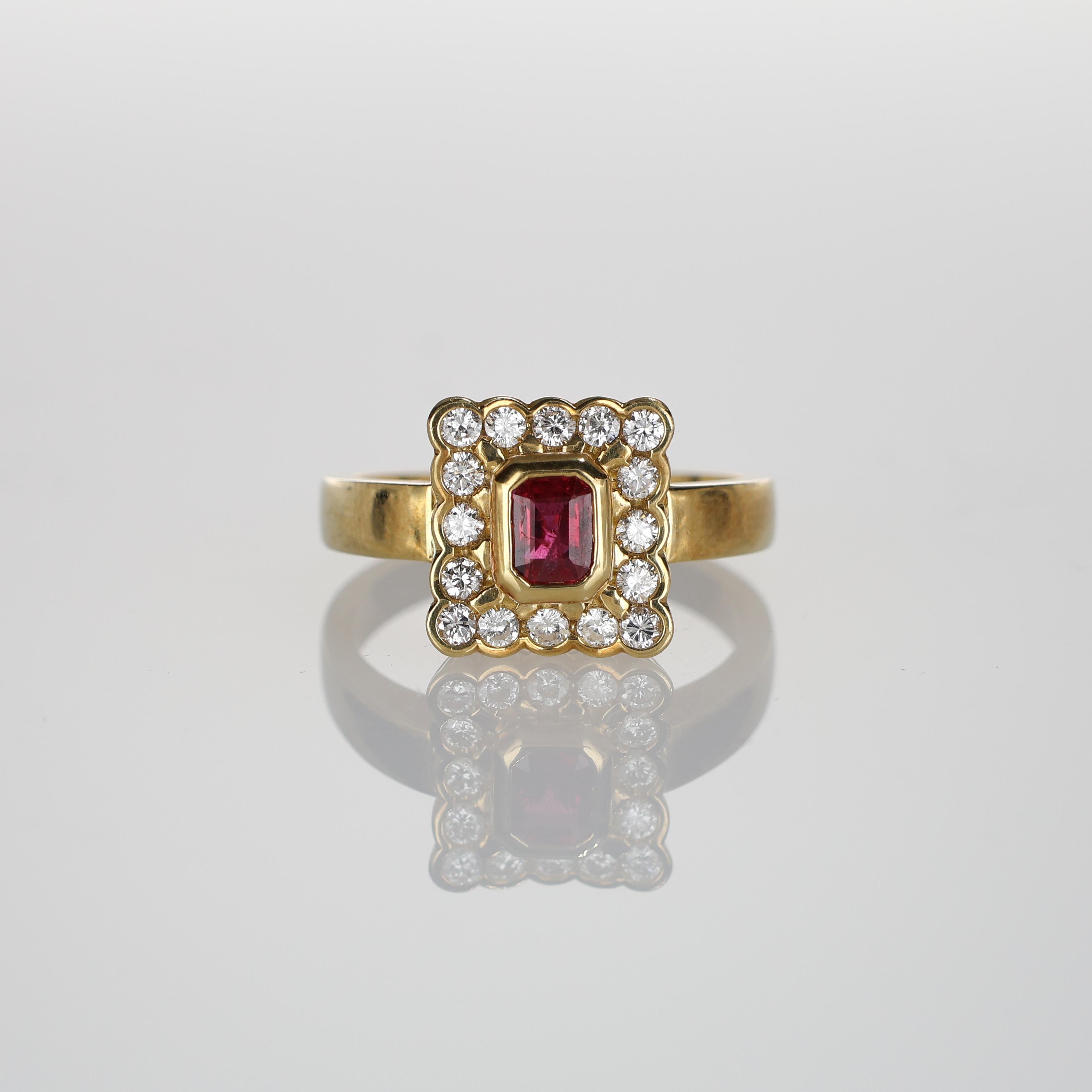 A sophisticated 18k yellow gold ring featuring a striking rectangular-cut ruby surrounded by a halo of natural white diamonds. This timeless design embodies elegance and luxury, perfect for a refined addition to any jewelry collection. The