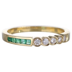 Anillo Riviera de oro amarillo de 18k con esmeraldas talla baguette y diamantes brillantes