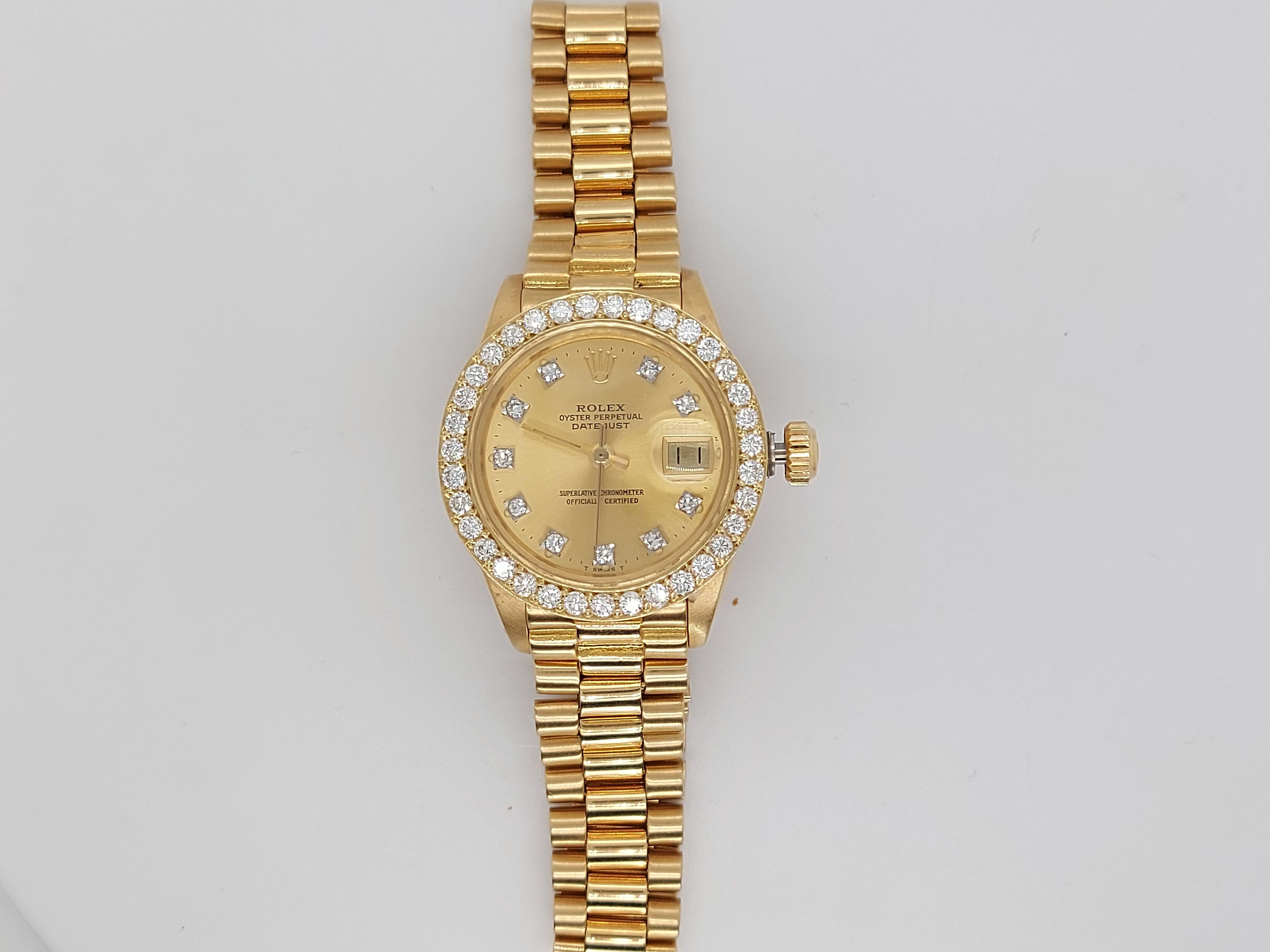 18Kt Yellow Gold, Rolex Ladies - Datejust President  Champagne Dial With Diamonds  in Perfect condition.

Movement: Automatic

Functions: Hours, Minutes, Seconds, Magnified date window by the 3

Case: 18 kt yellow gold,  Diameter 26 mm, thickness