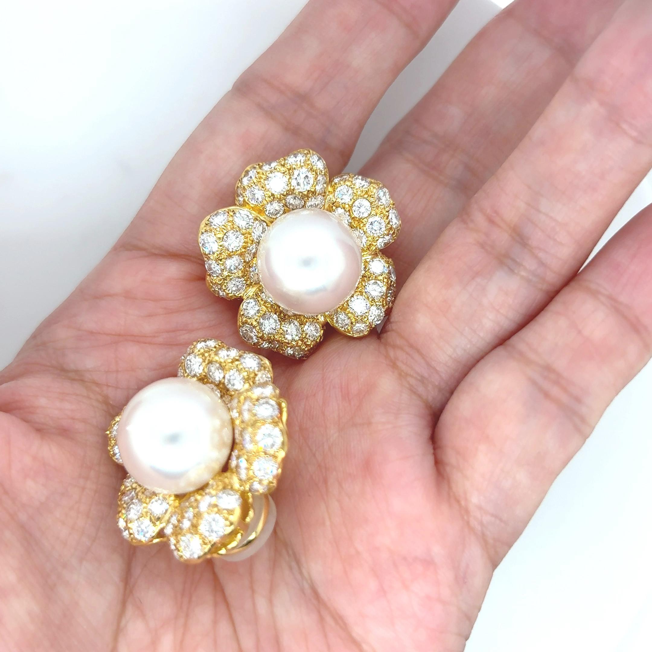 Ces boucles d'oreilles en forme de fleur présentent des perles lumineuses des mers du Sud provenant des eaux pures d'Australie, nichées parmi 7,78 carats de diamants ronds éblouissants. 

Le tout est serti dans de l'or jaune 18 carats. 

Les perles