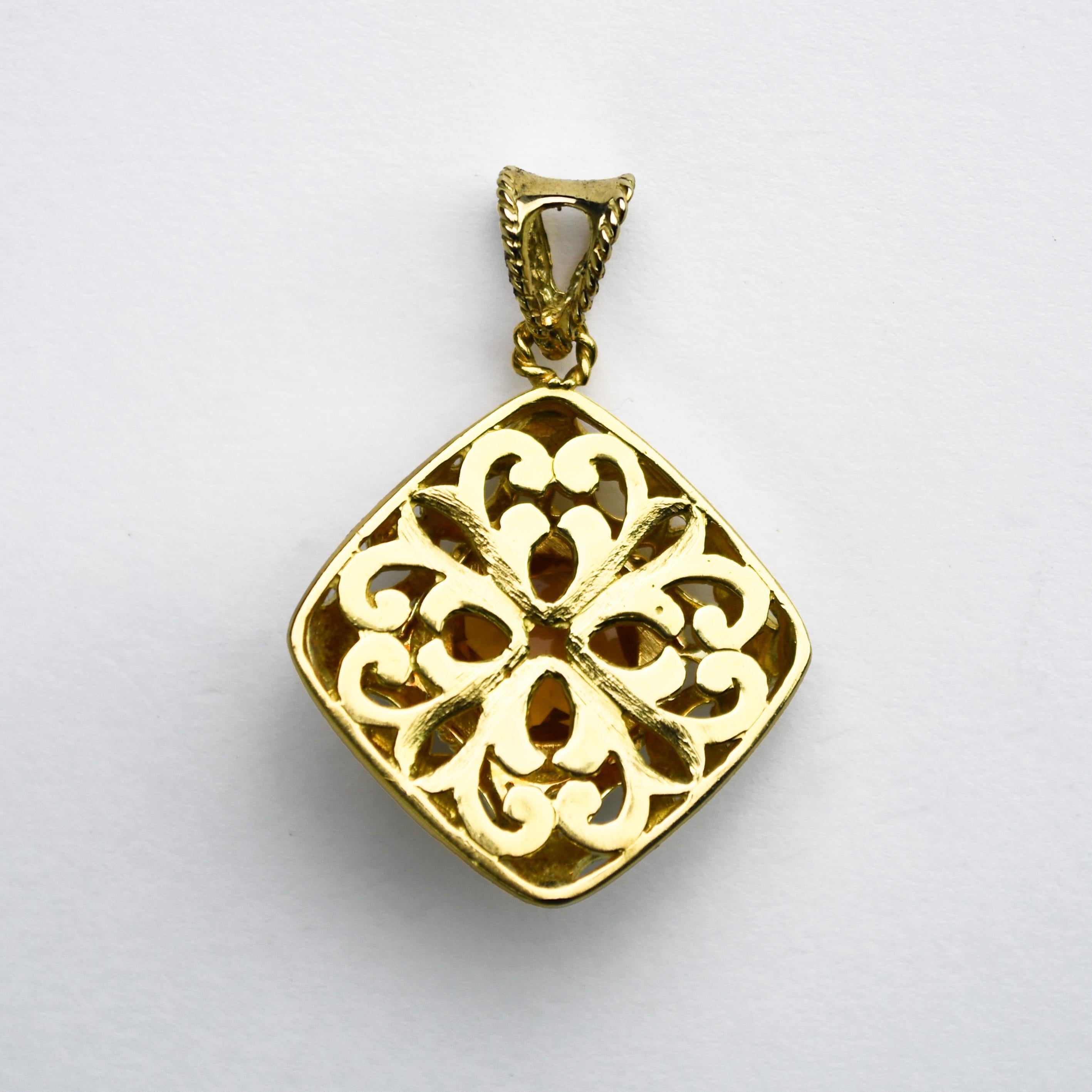 Le pendentif vintage en or jaune 18 carats pèse 12,0 grammes.
Elle contient une pierre précieuse solitaire en quartz citrine de forme ronde et de taille fantaisie, entourée d'un exquis travail de métal ouvert.
Le pendentif mesure 1 1/8