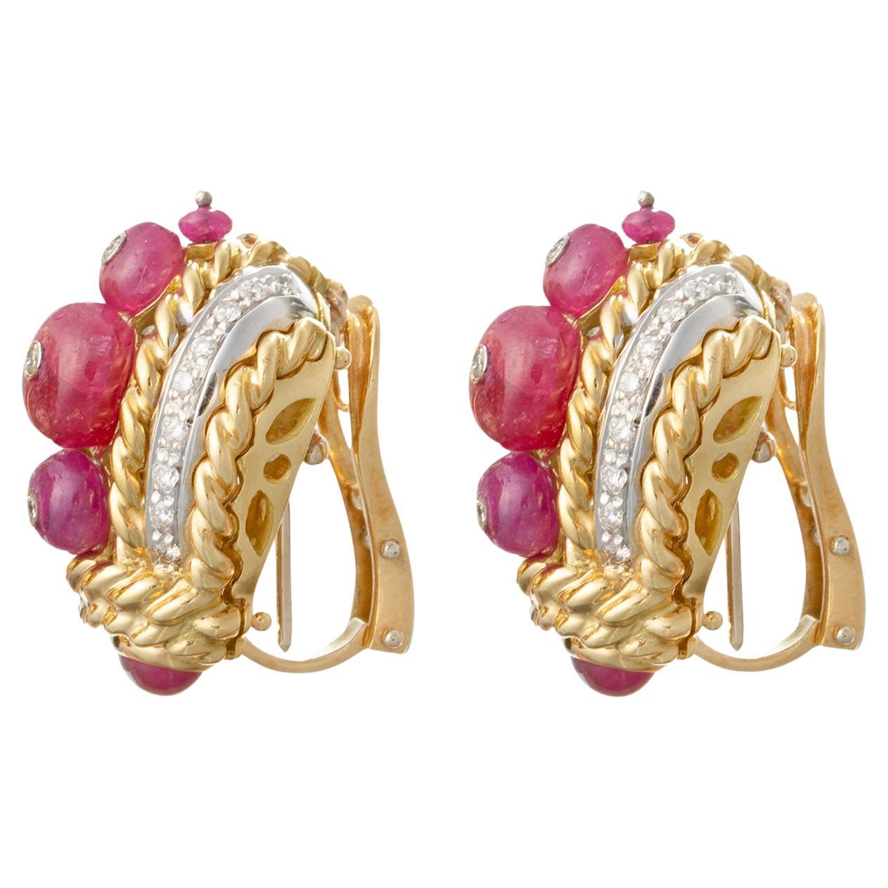 Clip earrings by Giovane Piranesi in a curved tapered design with rope-twist patterned accent in 18k yellow gold, each set with button-shaped rubies down the center and round brilliant-cut diamonds.  Forty-two diamonds weighing approximately 0.63