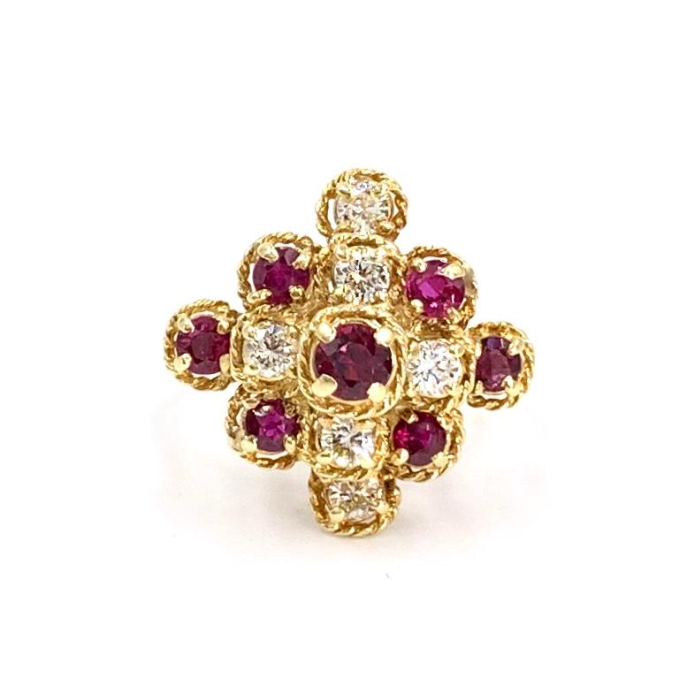 Circa 1960's, this unique 18k yellow gold tiered cluster style ring features six round brilliant diamonds at approximately .60 carats total weight and 7 well saturated round rubies at approximately 1 carat total weight. Each diamond and ruby is