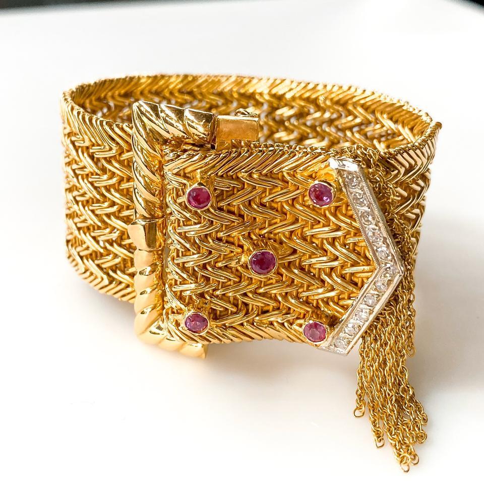 18K yellow gold buckle bracelet featuring 0.27 carats of round brilliant diamonds, 0.69 carats of faceted round rubies, chain-link fringe and push clasp closure with safety chain.
Metal Type: 18K Yellow Gold, Palladium
Hallmark: No Hallmark, Tested