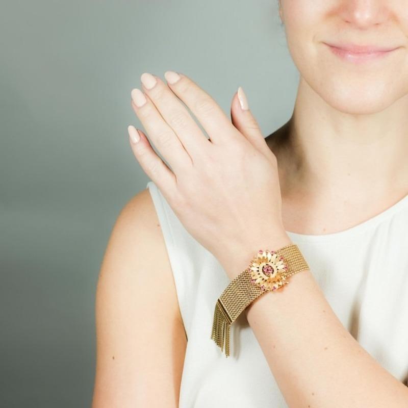 An 18K Yellow Gold Ruby Flower Slide Mesh Bracelet. The bracelet features a textured flower containing 12 round-cut rubies and box chain fringes at its end.

Stone: ruby

Metal: 18K Yellow Gold

Size: chain - 8 5/8