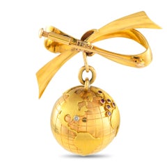 Broche globe en or jaune 18 carats et rubis