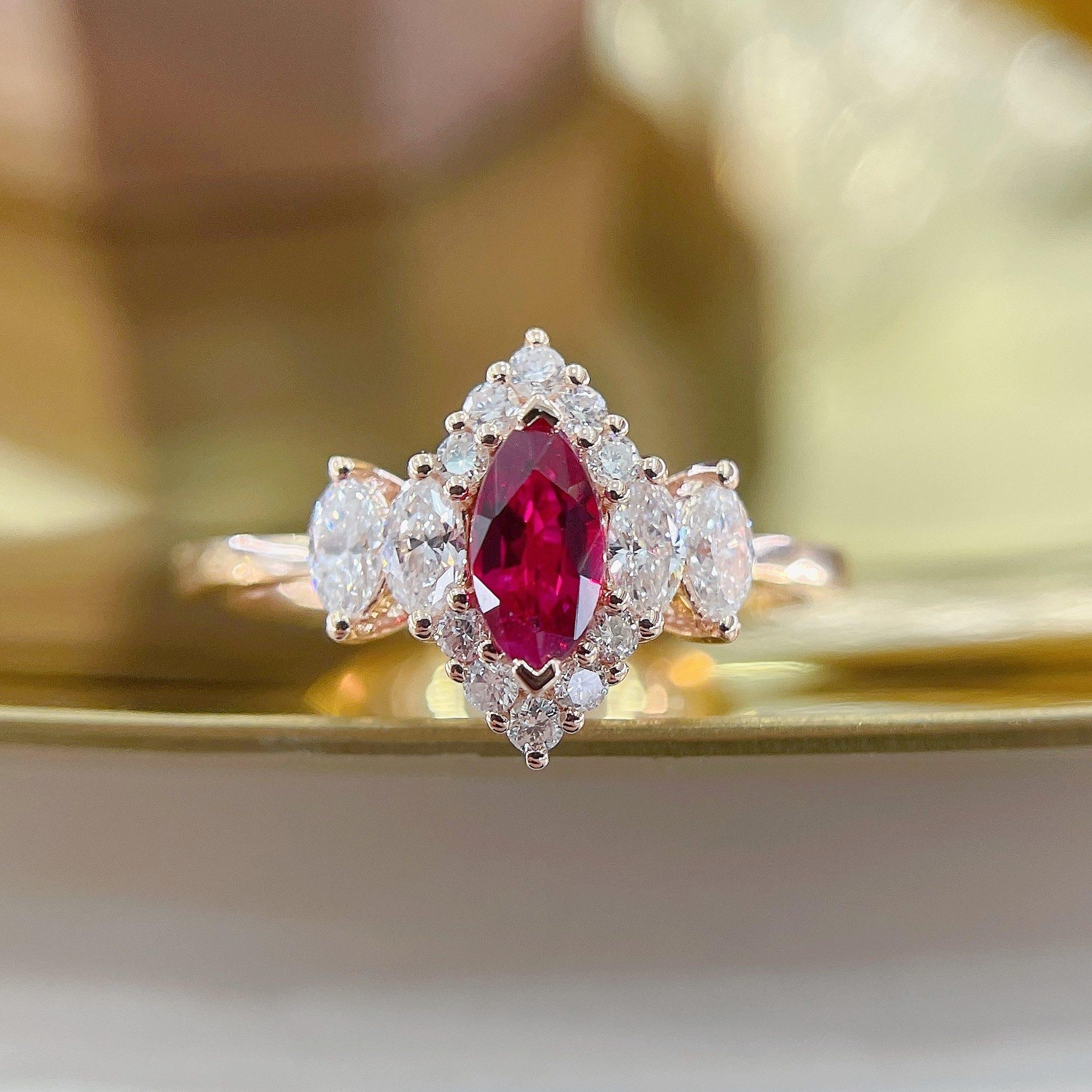 A captivating fusion of classic and modern, this 18K gold ring features a marquise-cut natural ruby of 0.26ct, enhanced by a dazzling arrangement of 0.31ct natural diamonds. The marquise shape elongates the finger, exuding grace and elegance.