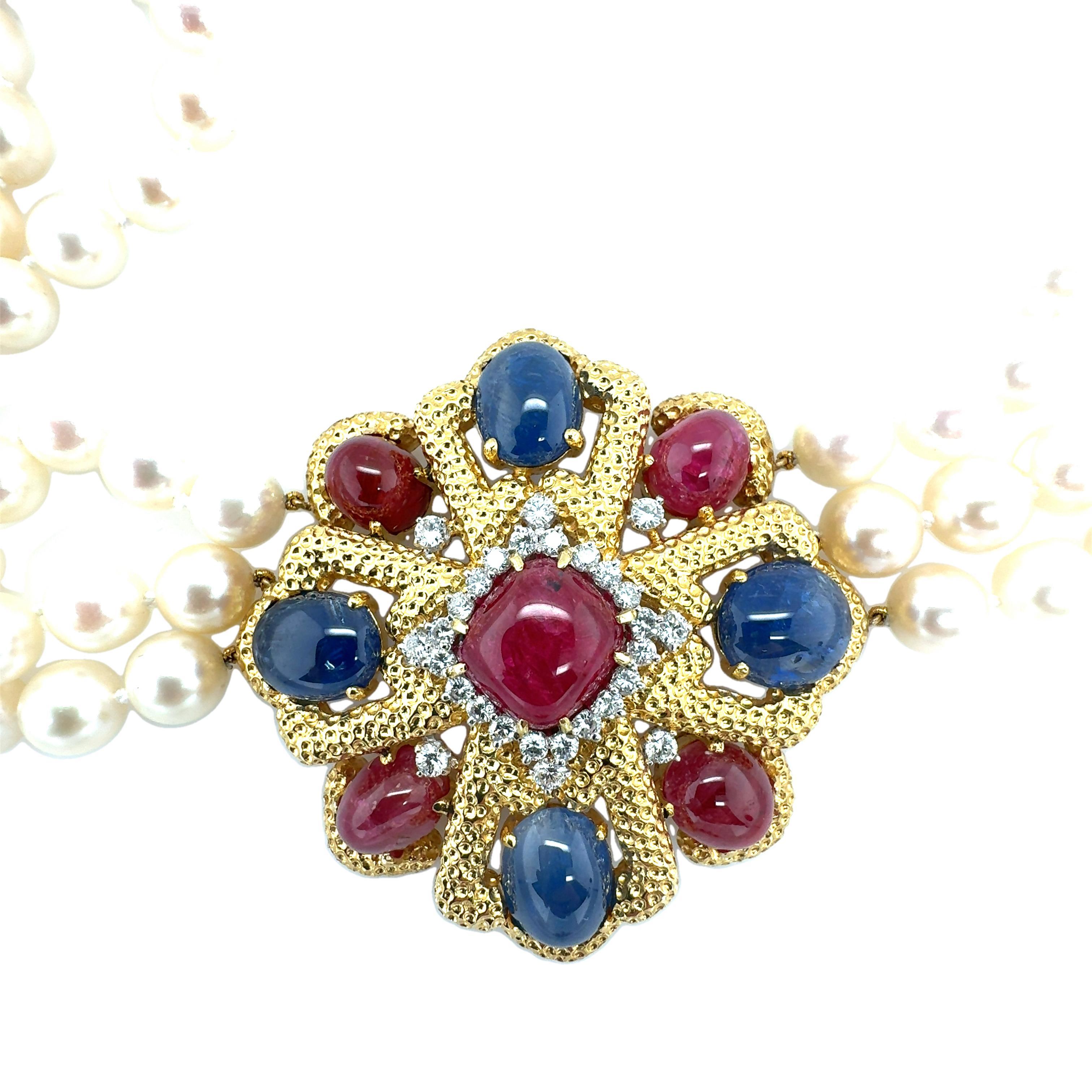 Cet extraordinaire collier en or jaune 18 carats est une véritable pièce d'apparat, présentant un élégant mélange de rubis, de saphirs, de diamants et de perles de culture qui incarnent le glamour des années 1970. Présentant cinq rubis taillés en