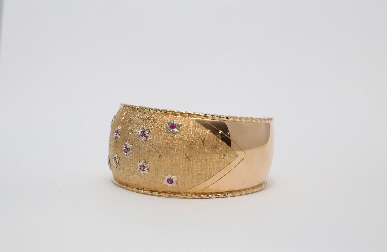 Este llamativo brazalete ancho de 18 quilates cautiva con su diseño de inspiración celestial y su intrincada artesanía. La superficie de oro cepillado sirve de lujoso telón de fondo a una constelación de estrellas de oro blanco, cada una de ellas