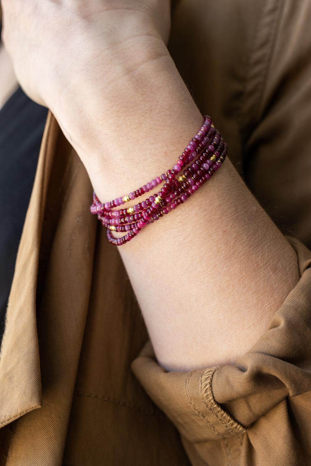 Introducing the stunning Wrap Bracelet with Rubies, featuring an impressive 77.35-carat total weight of radiant rubies complemented by 18k yellow gold beads. Measuring 34